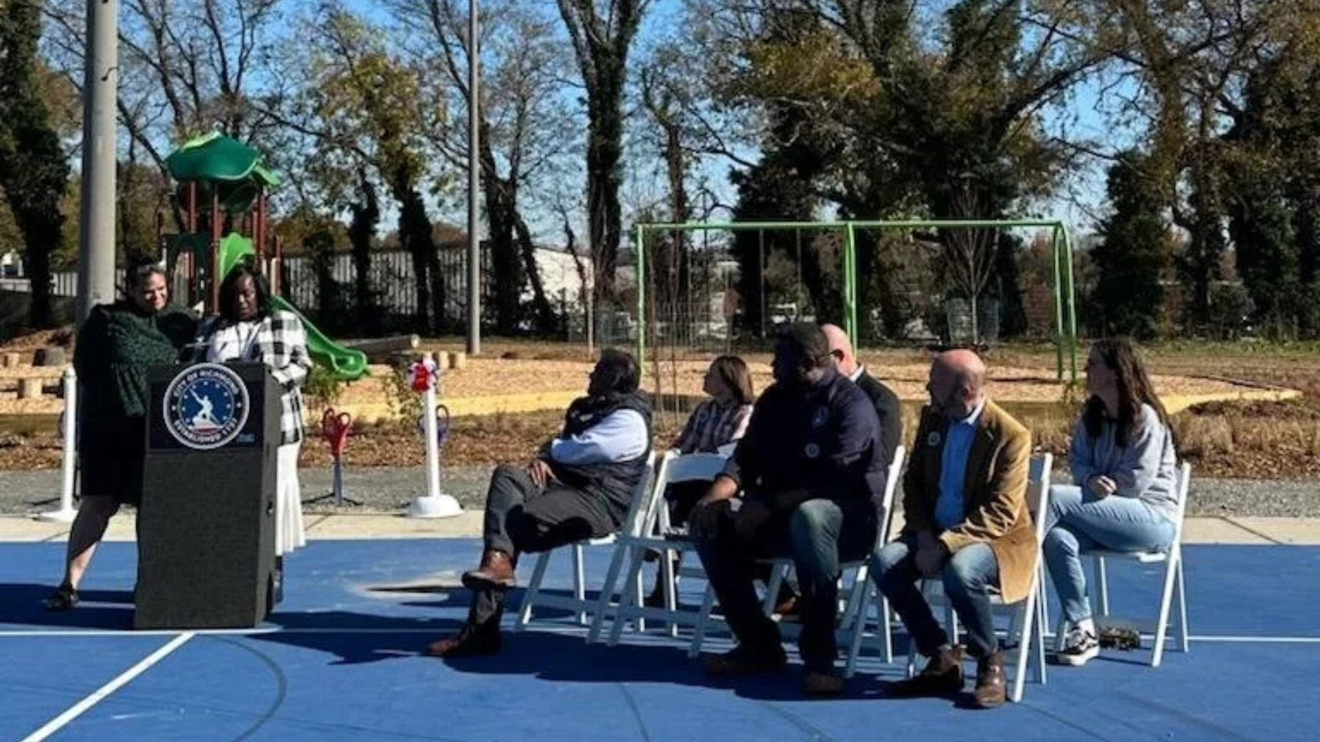 Southside ReLeaf co-founder Amy Wentz speaks at the podium with Reverend Dana Sally-Allen at the ribbon cutting for Blackwell Park in November 2025.