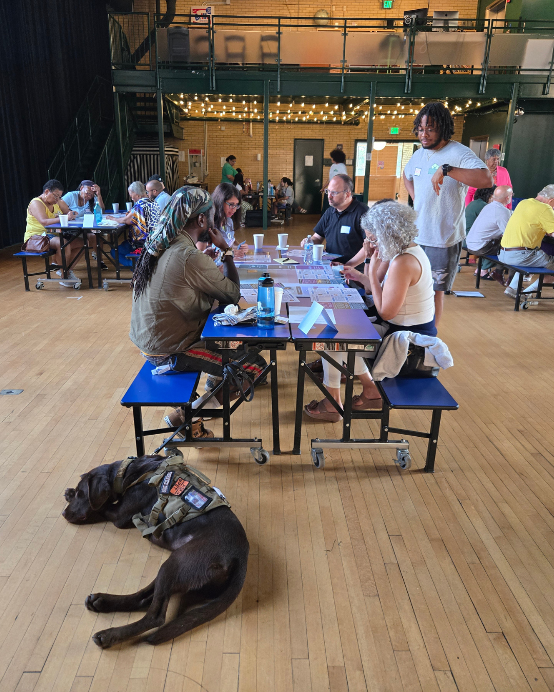 A group of residents speaks with Glen Allen from Virginia Interfaith Power & Light as they consider how they would invest city funds to support resilience at the June 23, 2025 forum at Studio Two Three.