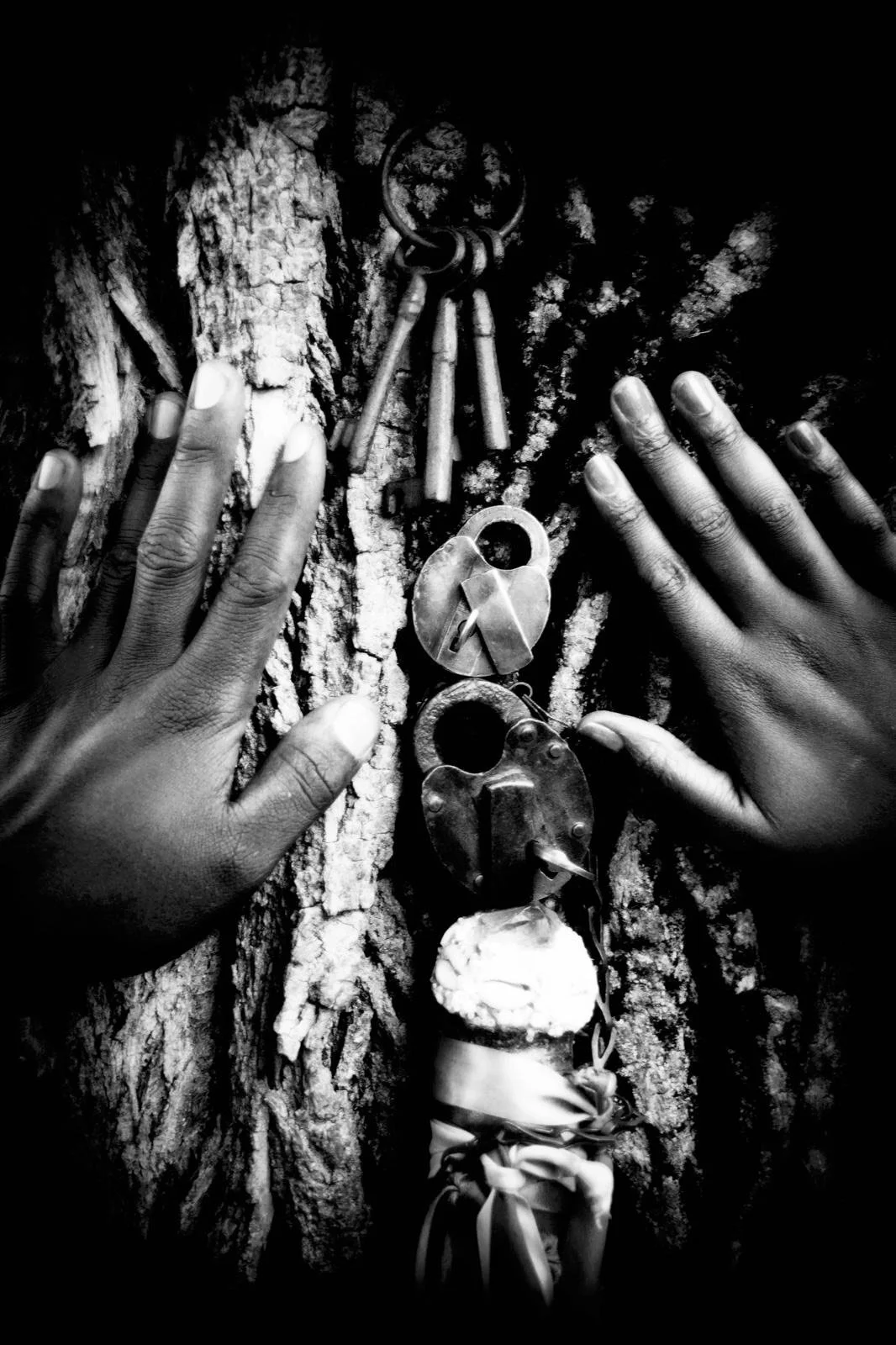 Antique locks and keys nestled among the trees embraced by a Brown woman and man's hands