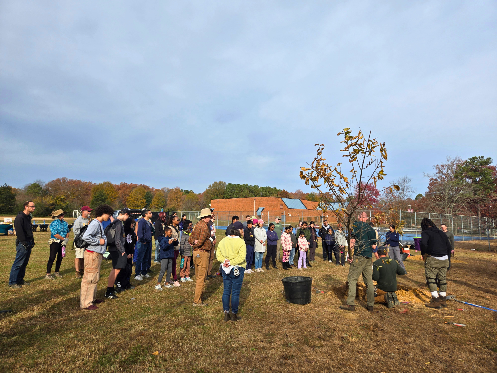 Michael Gee (Richmond PRCF), Brian Scott, and Da’Vantae “Blue” Ballou (Groundwork RVA) demo how to plant a tree.