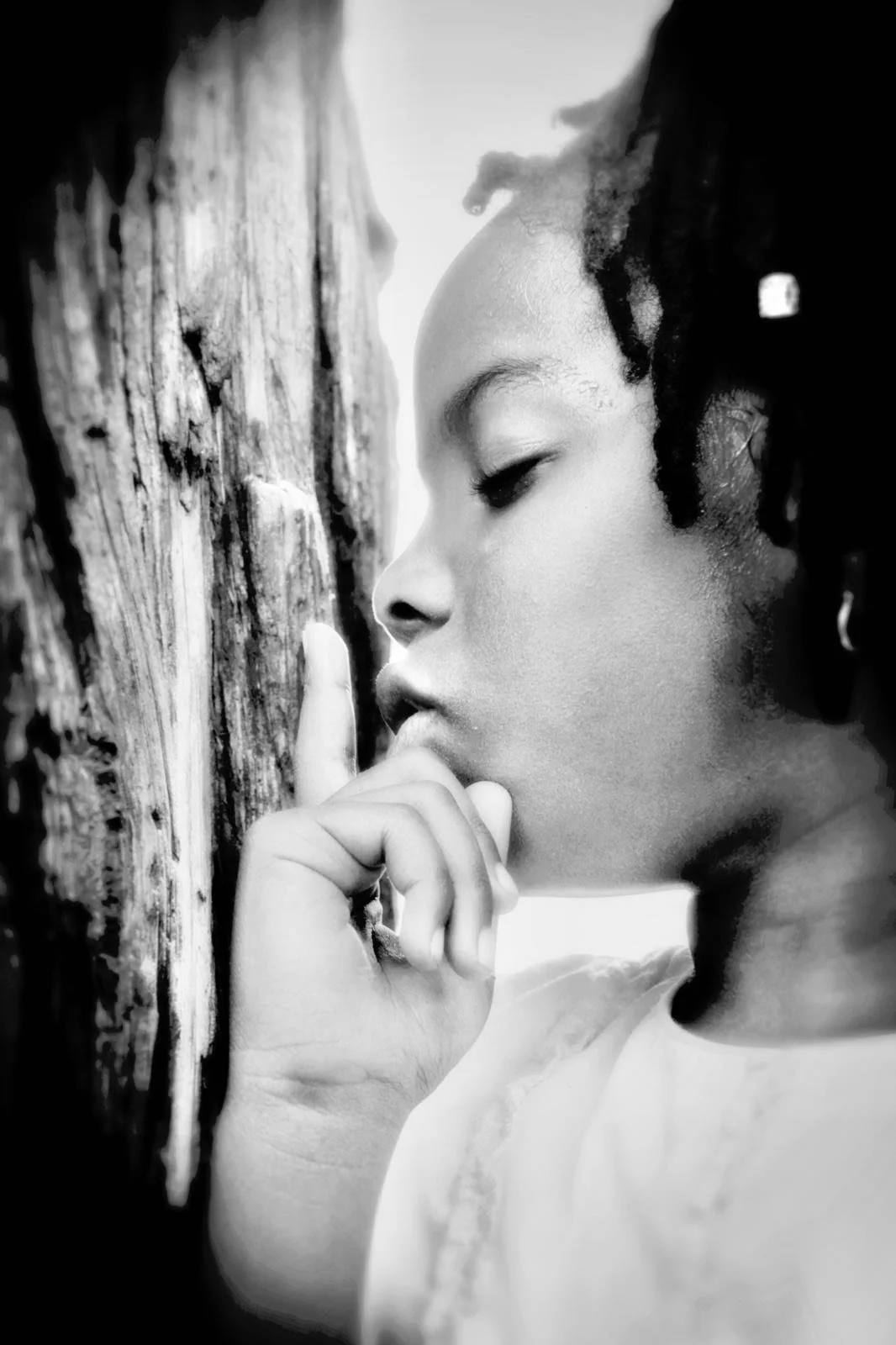 Beautiful Brown girl whispering her promise to a tree