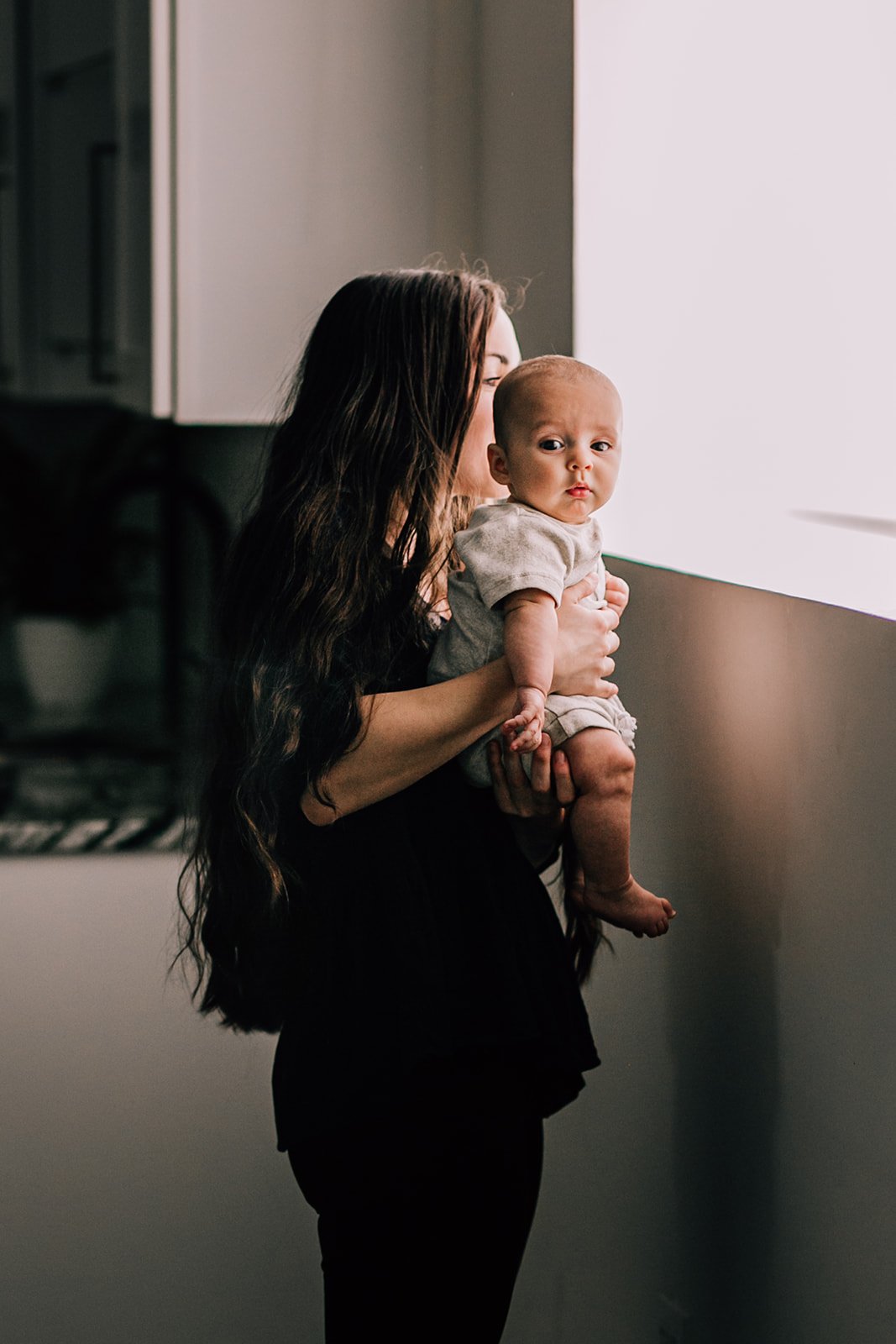 mom-cuddling-baby-stand-in-sunlight.jpg