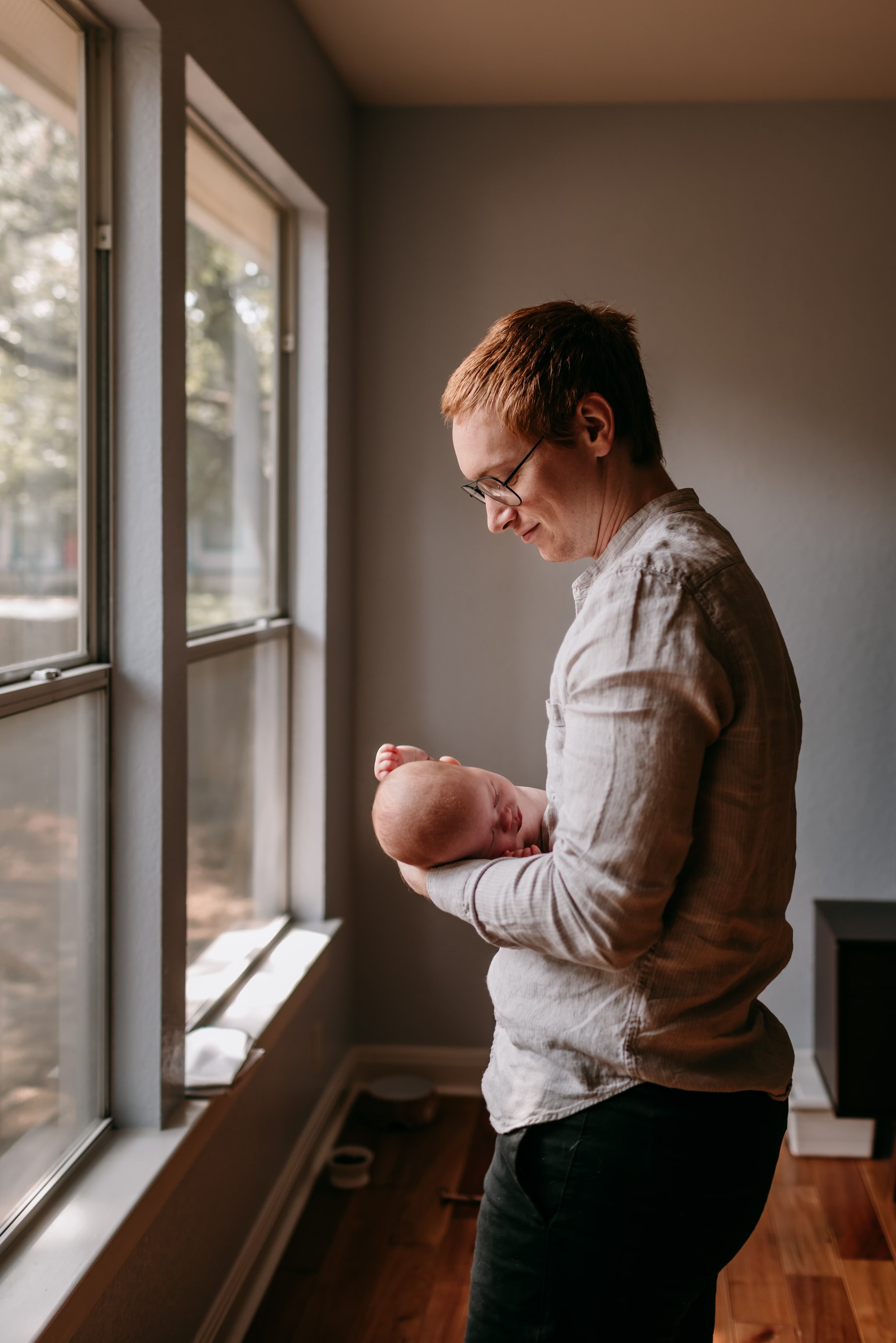 father-holding-newborn-by-window.jpg