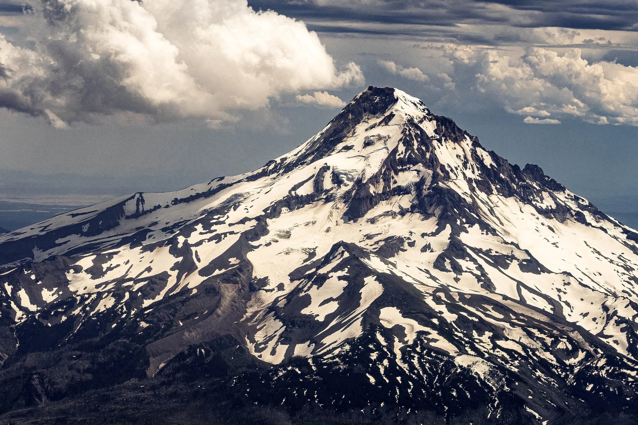 Close detail of Mount Hood's snow-covered summit, ridges, and dark volcanic slopes