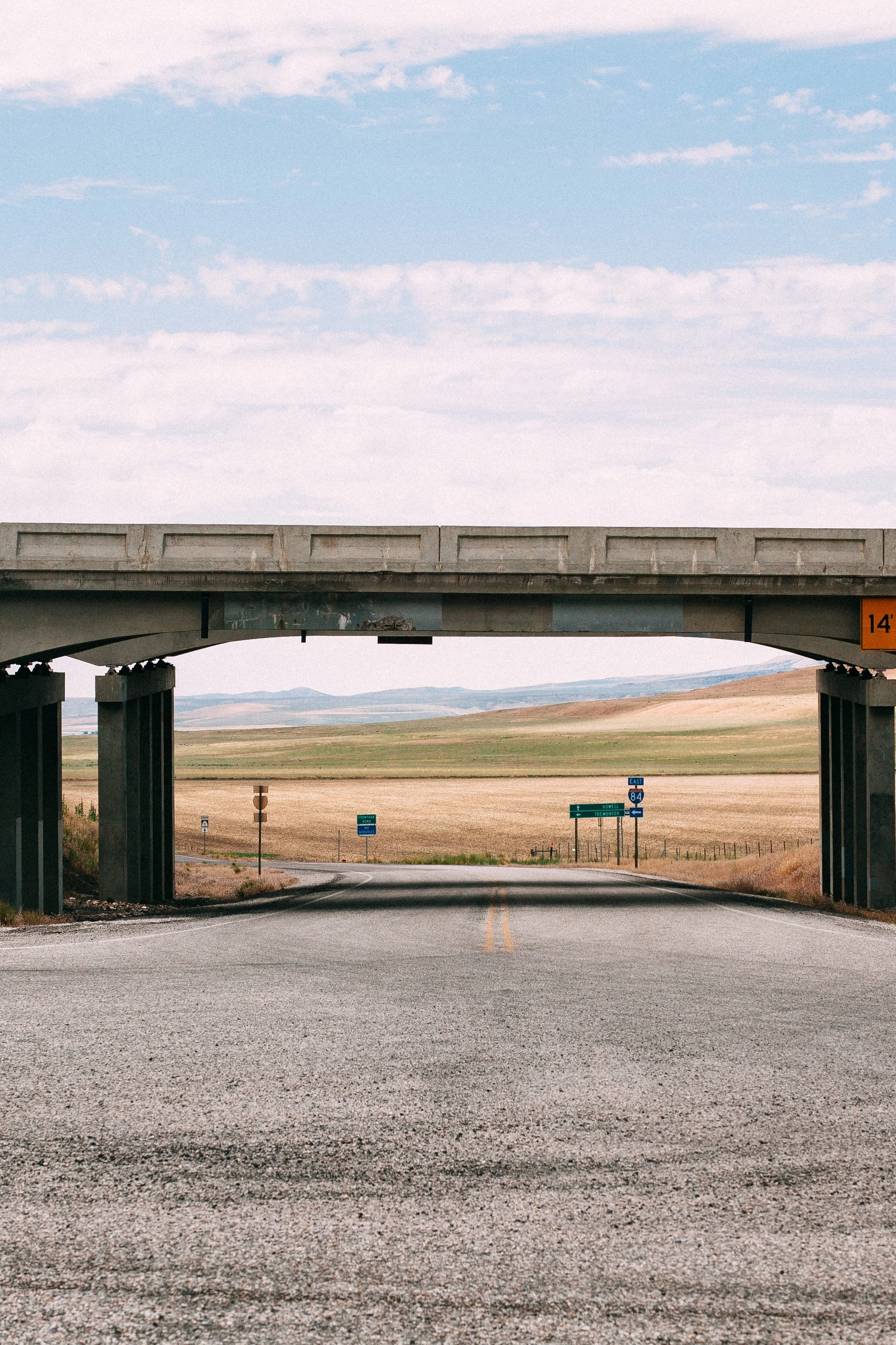 Vertical detail of the overpass opening, center line, distant signs, and open plains