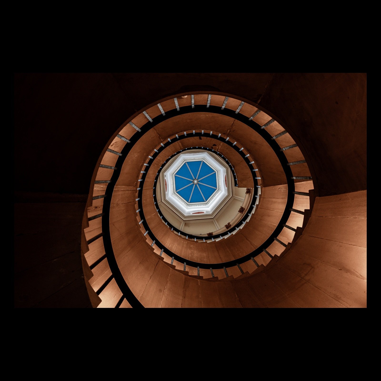 Higher Enlightenment spiral staircase photograph presented in full against a black background