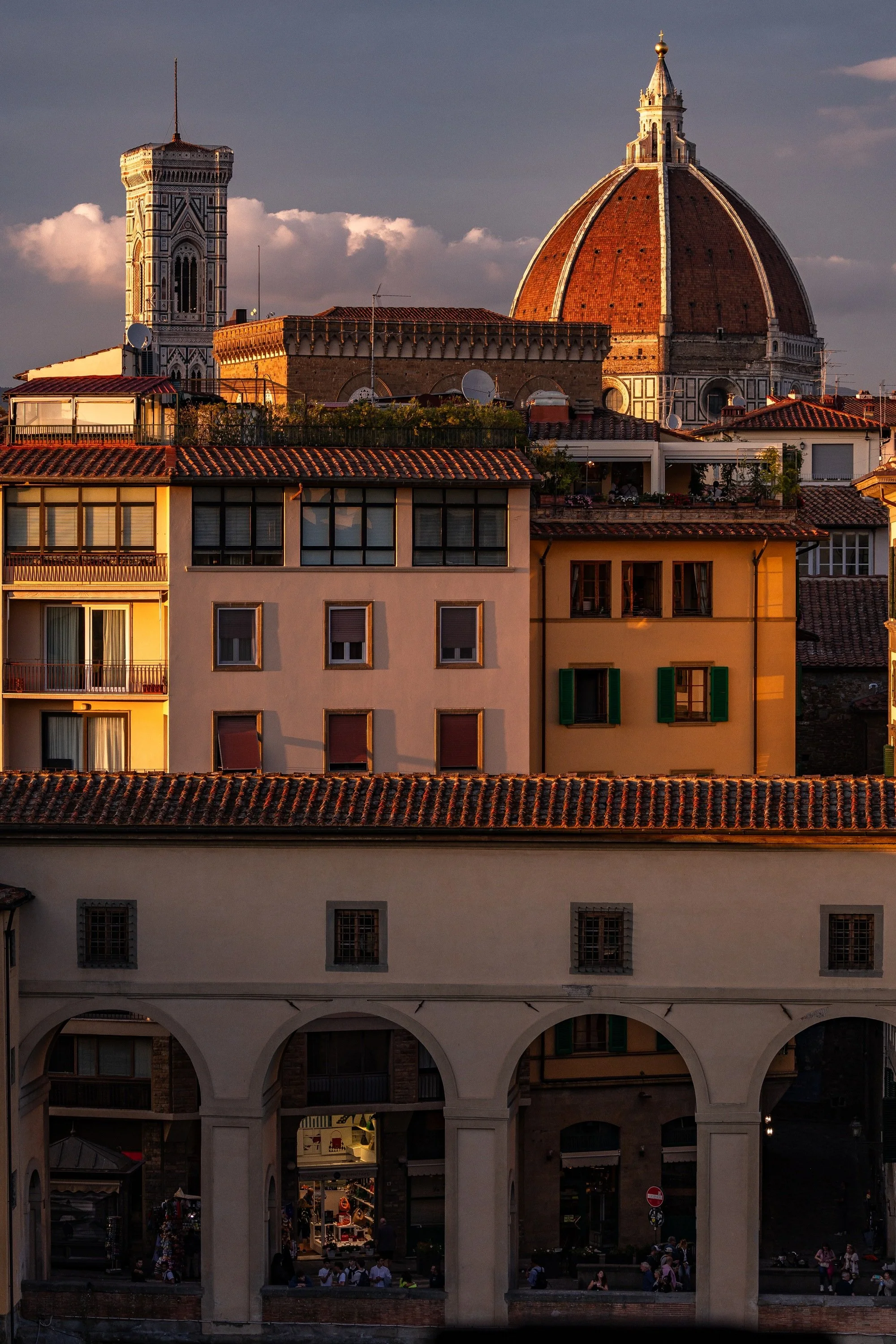 Florence city layers rising from shadowed arches and ochre apartments to the Duomo and Giotto's Campanile