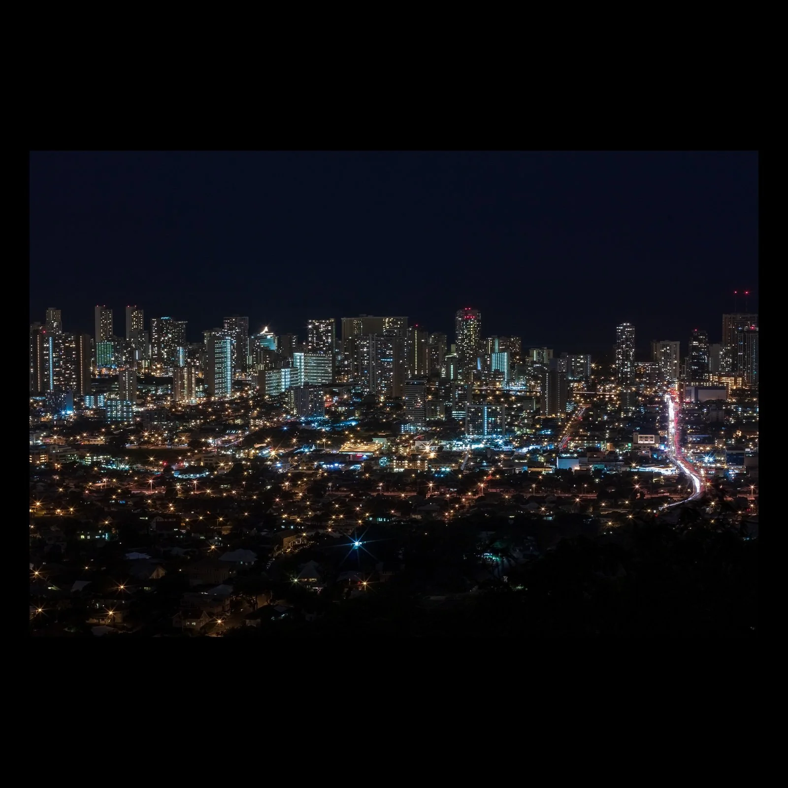 Full-frame black presentation thumbnail of Electric Horizon, showing a city skyline glows beneath a nearly black sky, with traffic forming a bright line through the foreground