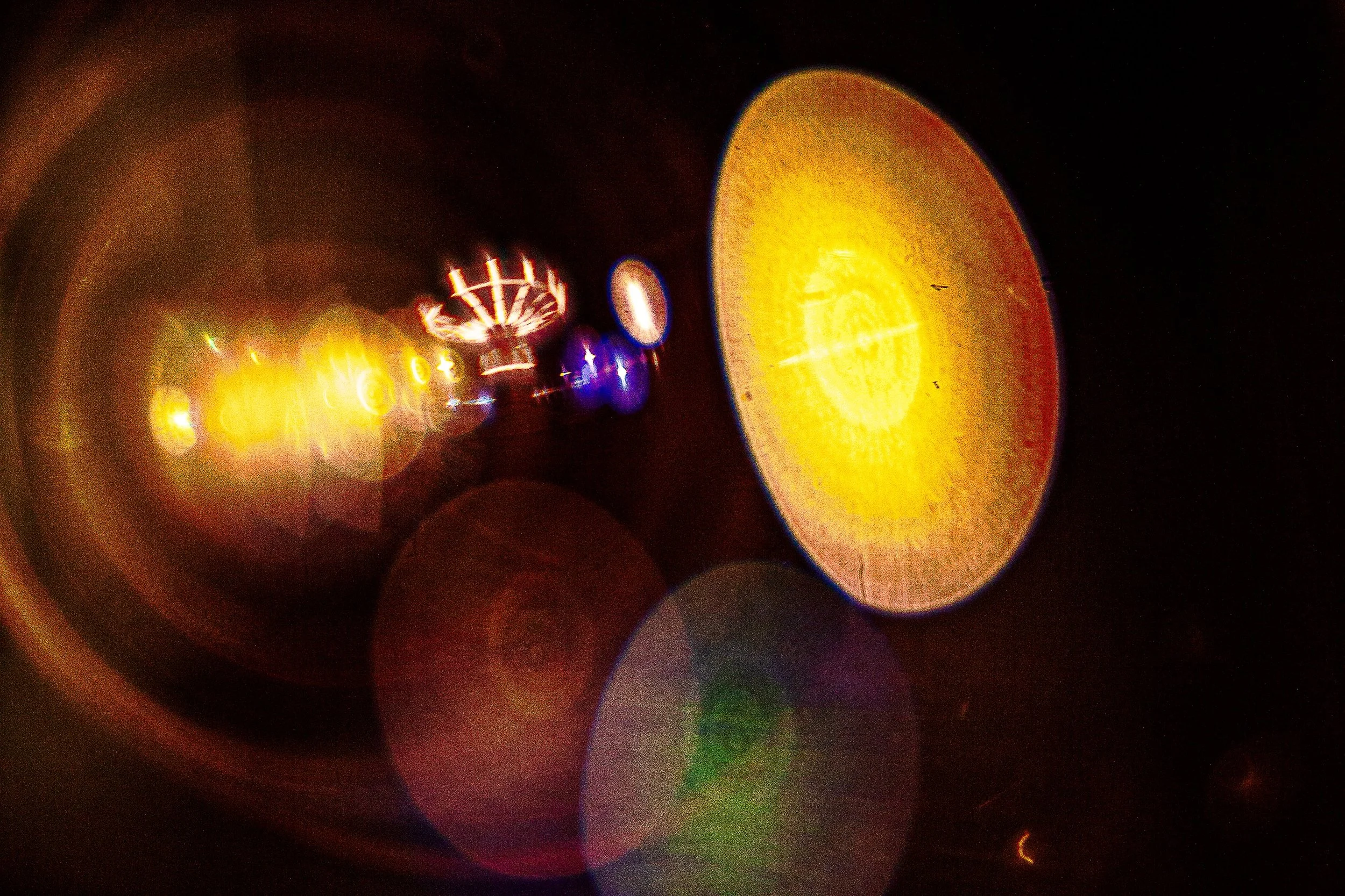 Complete uncropped artwork for Midway Orbit, showing state-fair lights dissolve into circular amber and colored forms against deep black