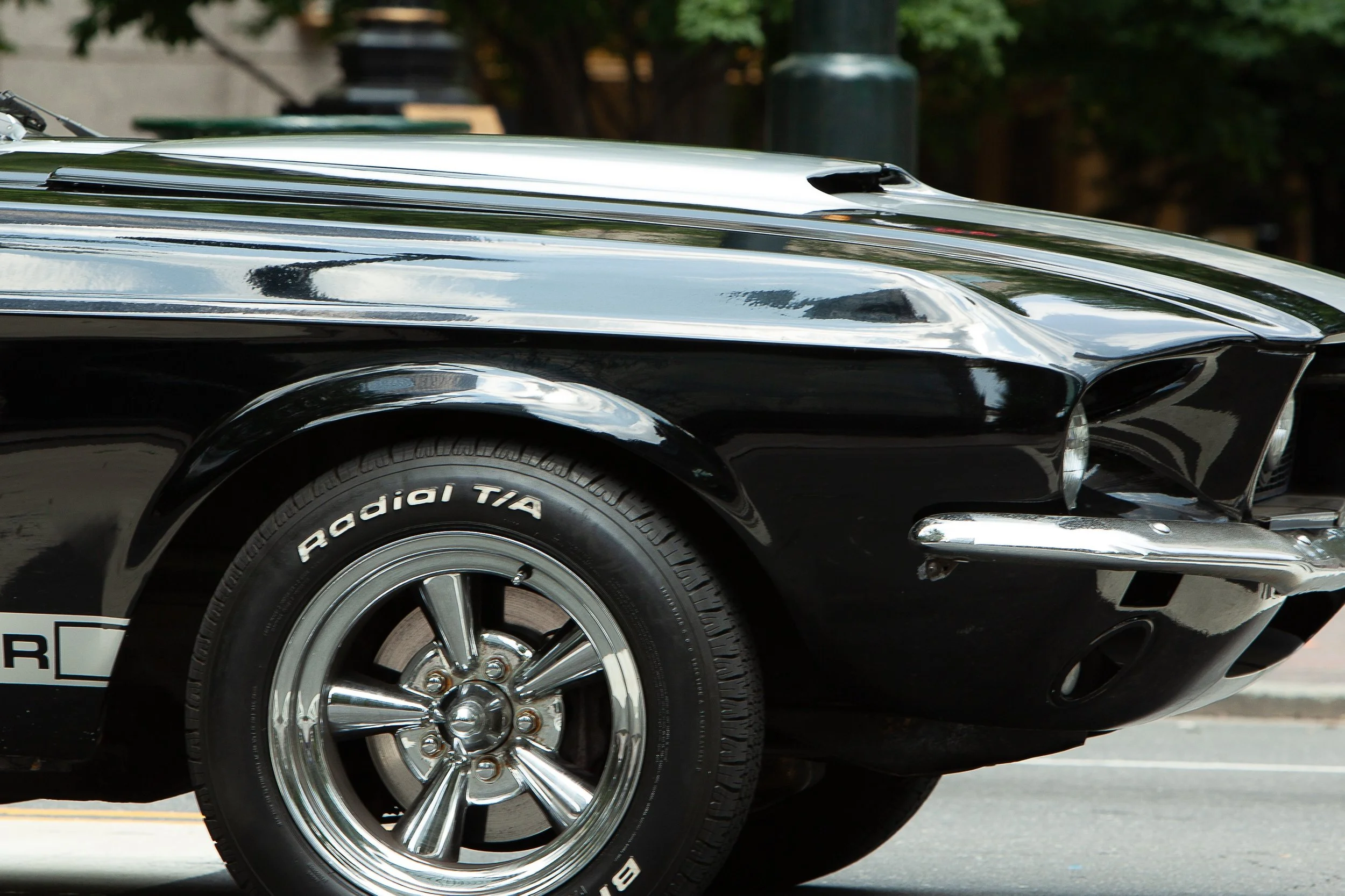 Detail crop from Five Hundred Horses, emphasizing lettering, tire texture, and reflected buildings reward a closer look