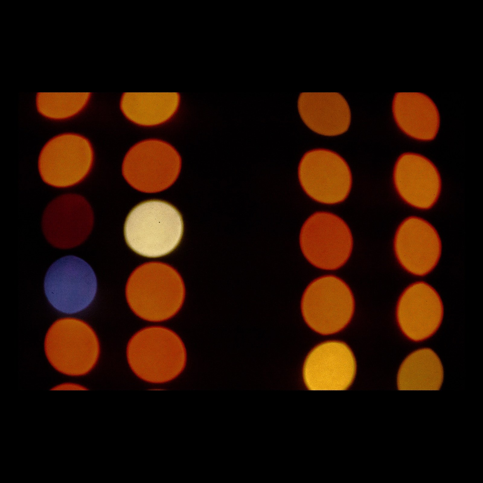 Full-frame black presentation thumbnail of Signals at Night, showing rows of warm circular lights float against black with a few cool colors interrupting the pattern