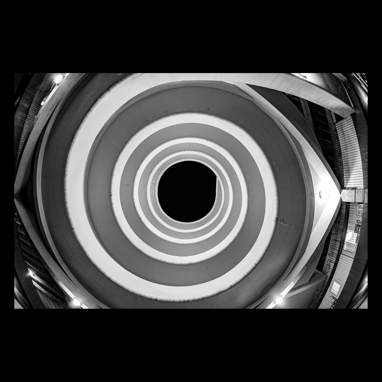 Full-frame black presentation thumbnail of Circular Reasoning, showing concentric architectural rings narrow toward a black center in a monochrome upward view