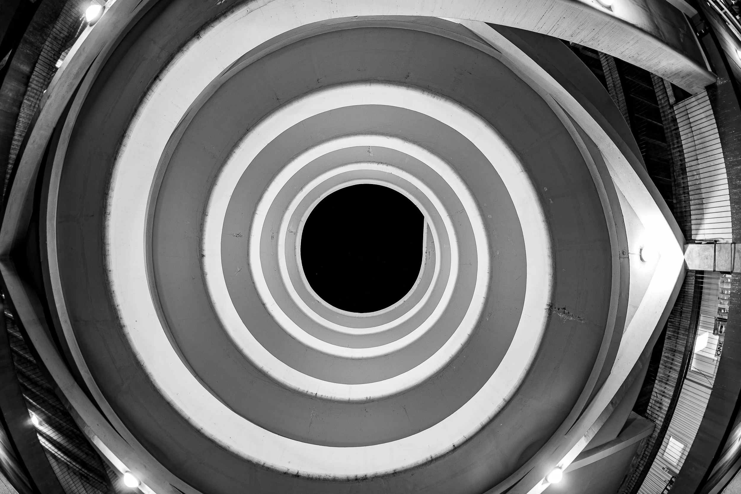 Complete uncropped artwork for Circular Reasoning, showing concentric architectural rings narrow toward a black center in a monochrome upward view