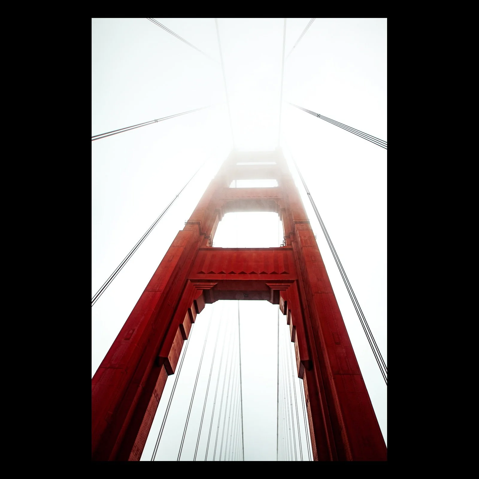 Full-frame black presentation thumbnail of Red Span, showing a red suspension-bridge tower rises vertically into a pale fog-filled sky