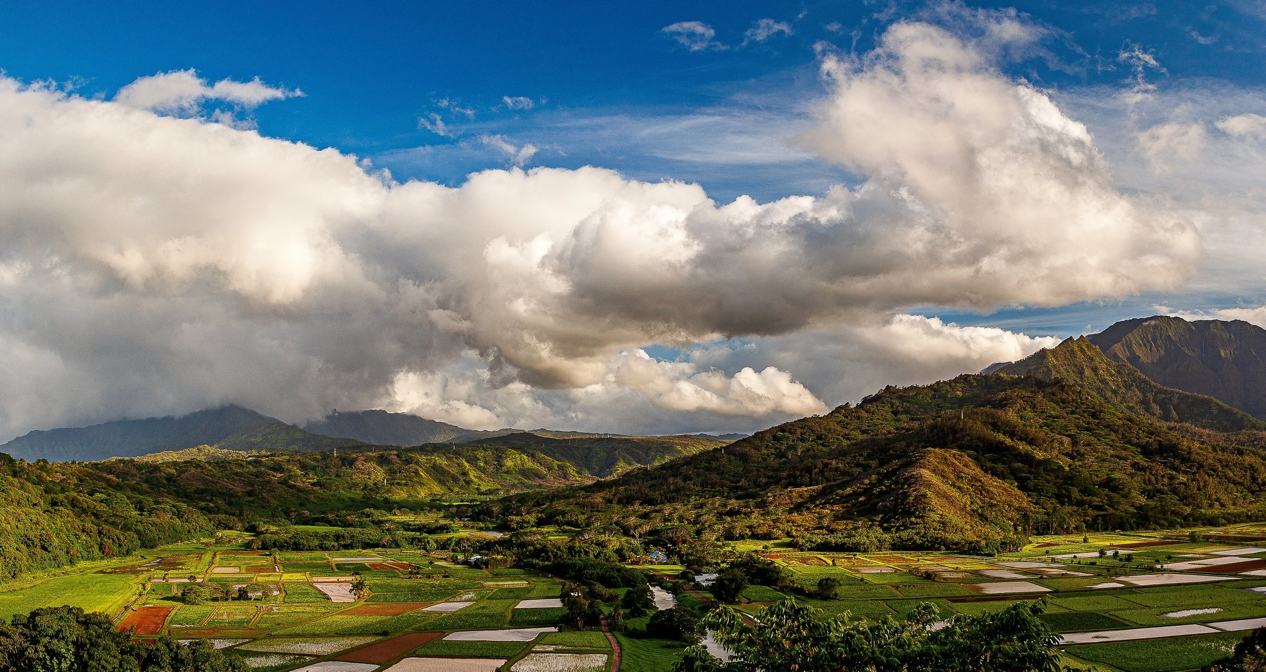 Complete uncropped artwork for Weather Over the Fields, showing heavy white clouds gather above a patchwork of fields and low mountain ridges