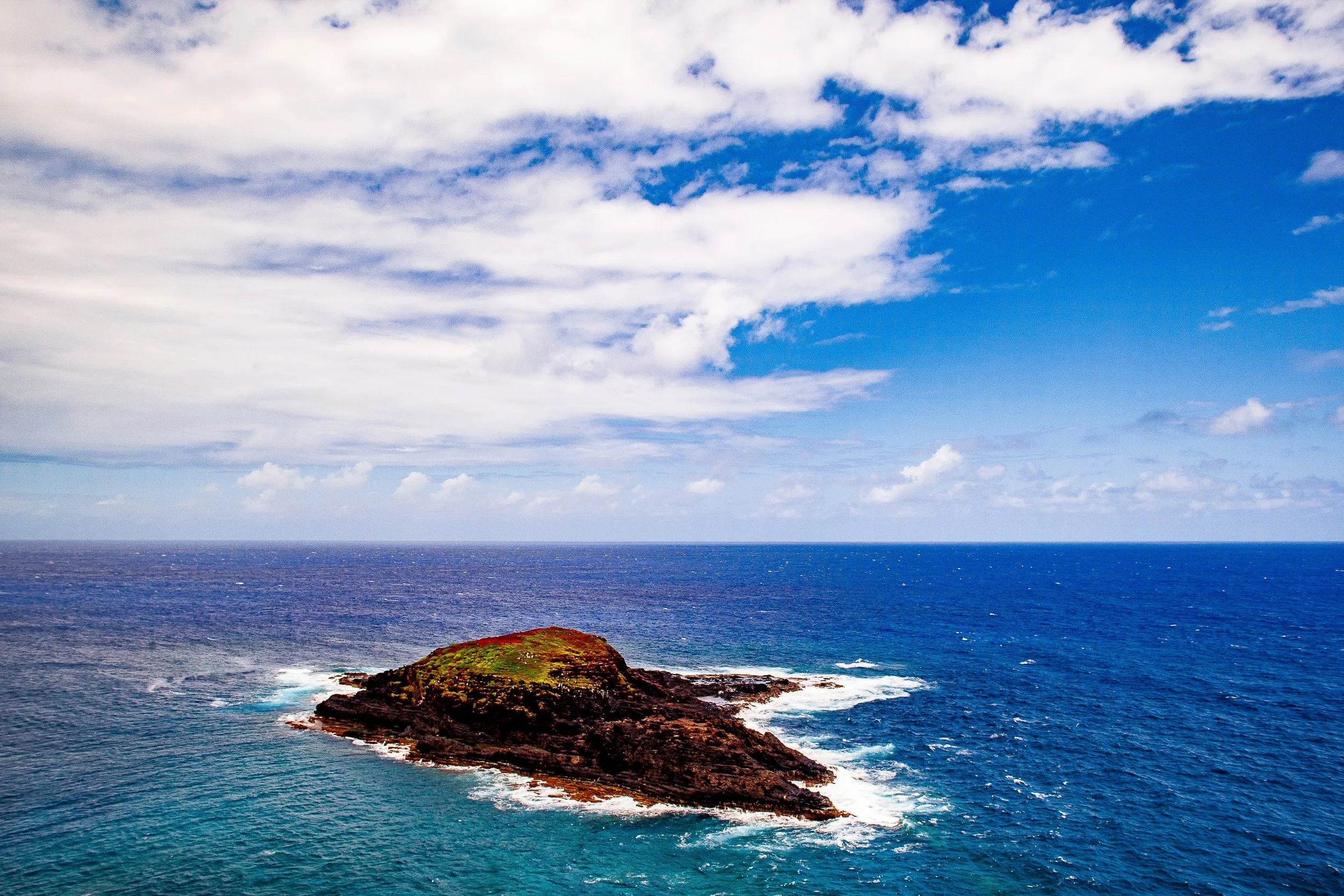 Complete uncropped artwork for Offshore Geometry, showing a low rocky island sits inside rings of white surf against a wide blue sea