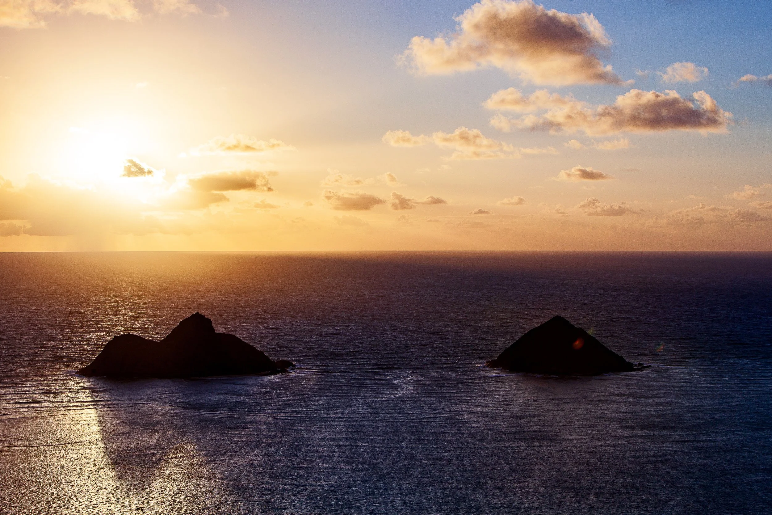 Complete uncropped artwork for Twin Islands at Dusk, showing two dark offshore islands divide a warm sunset reflected across calm water