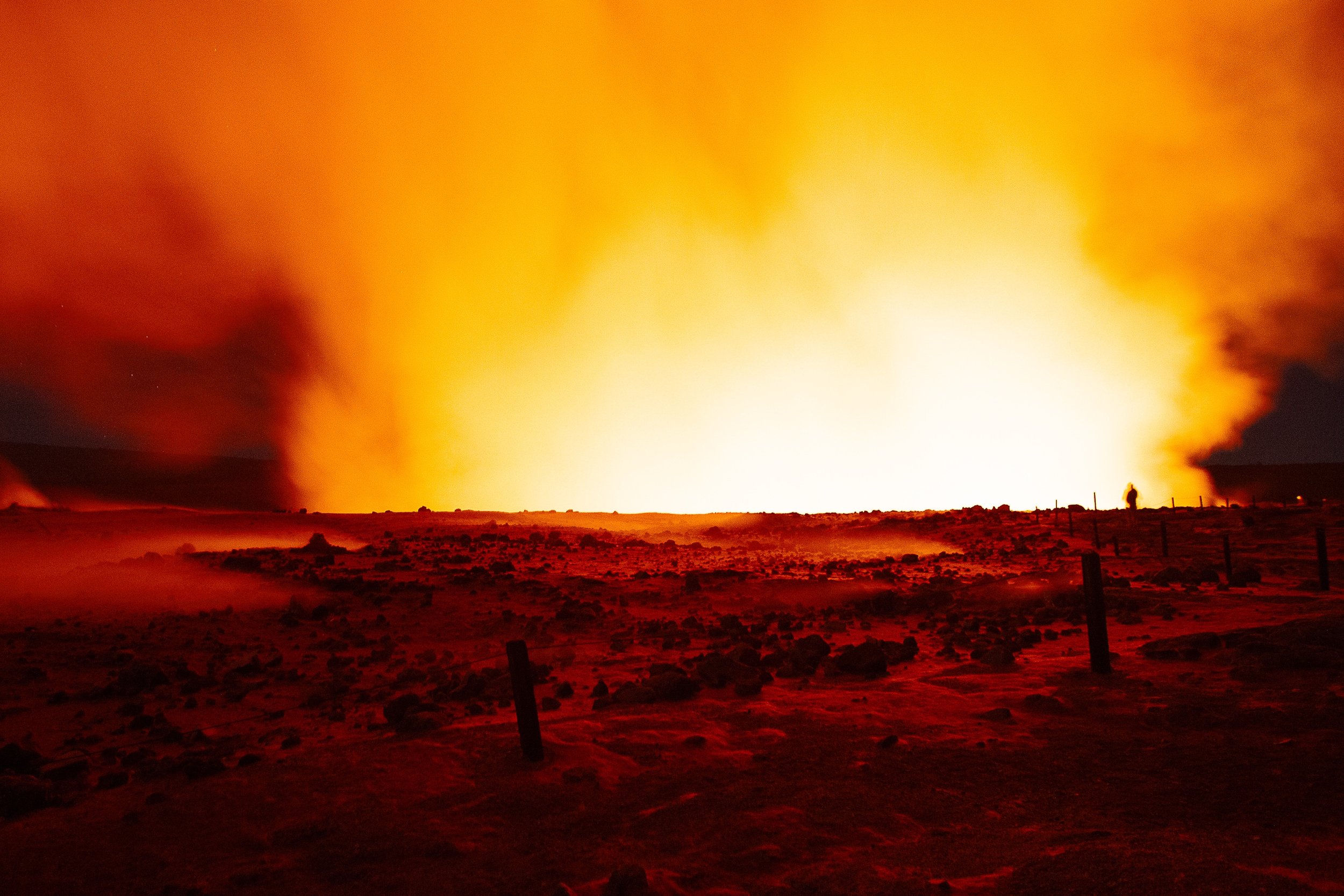 Detail crop from Before the Lava, emphasizing tiny figures and rough foreground textures give scale to the distant eruption