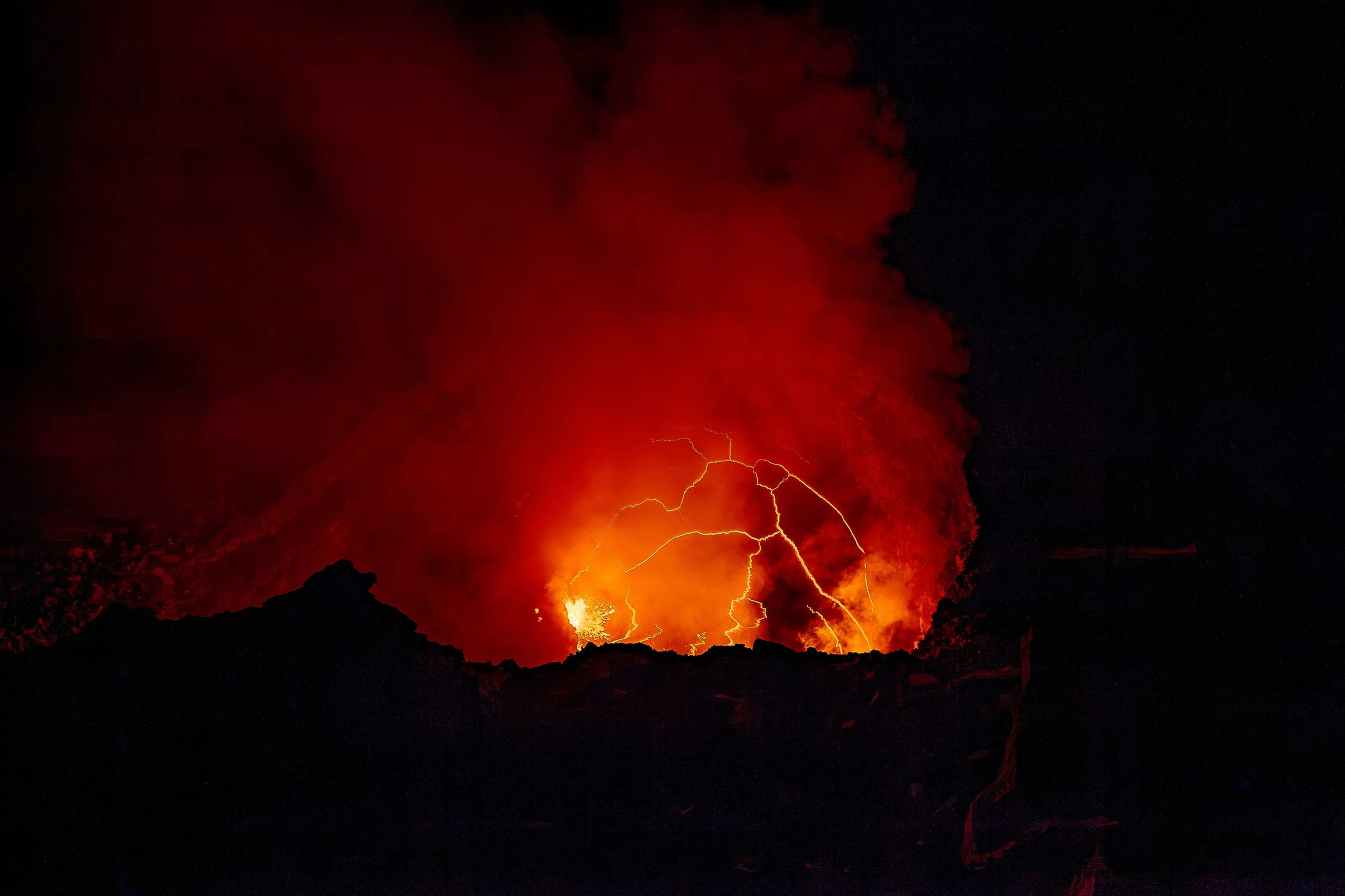 Complete uncropped artwork for Fire Writes Back, showing red volcanic light and branching lightning appear together beneath a dense black sky