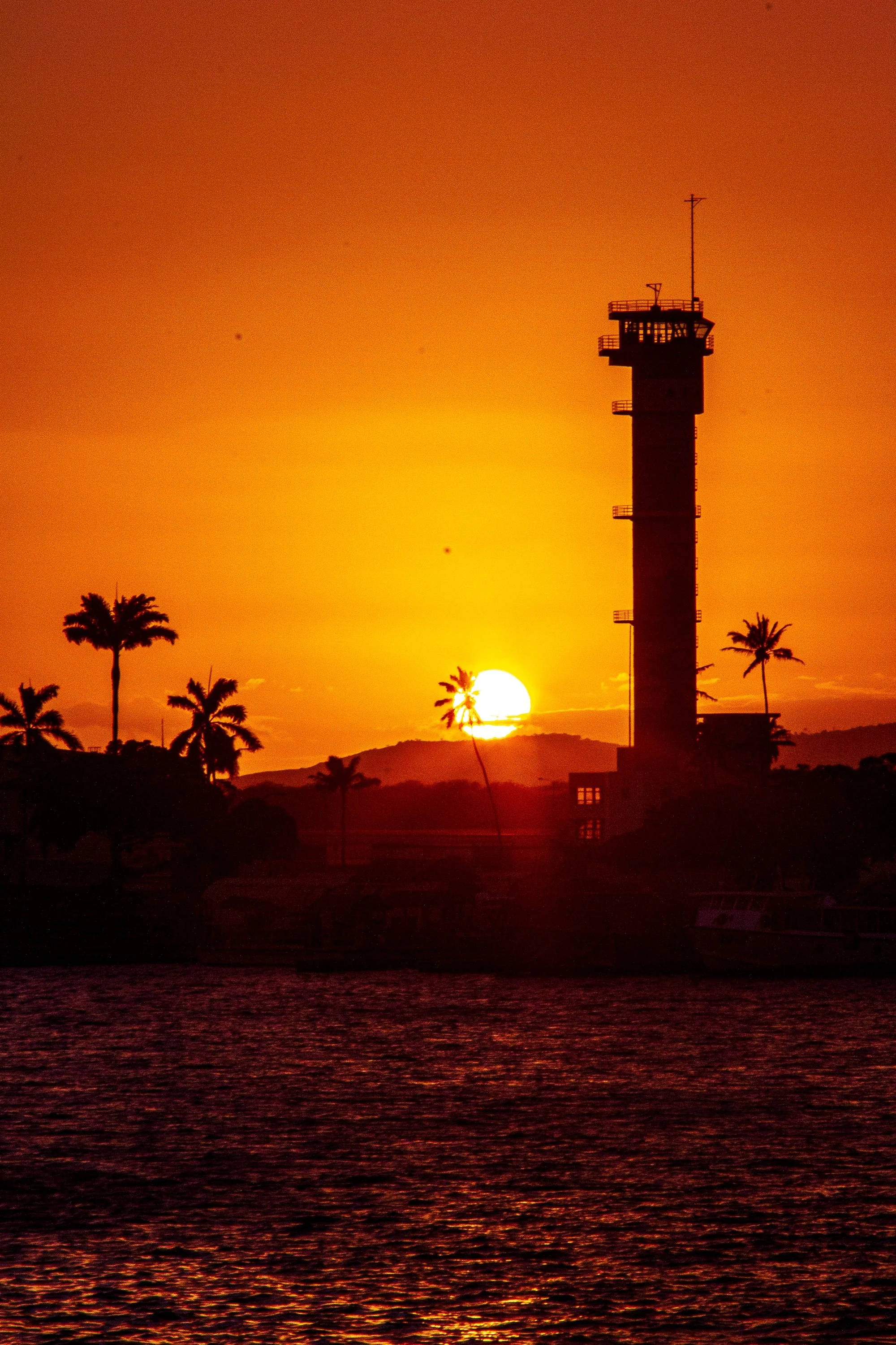 Complete uncropped artwork for Last Watch, showing the sun sets beside a silhouetted harbor tower and palms in a narrow vertical composition
