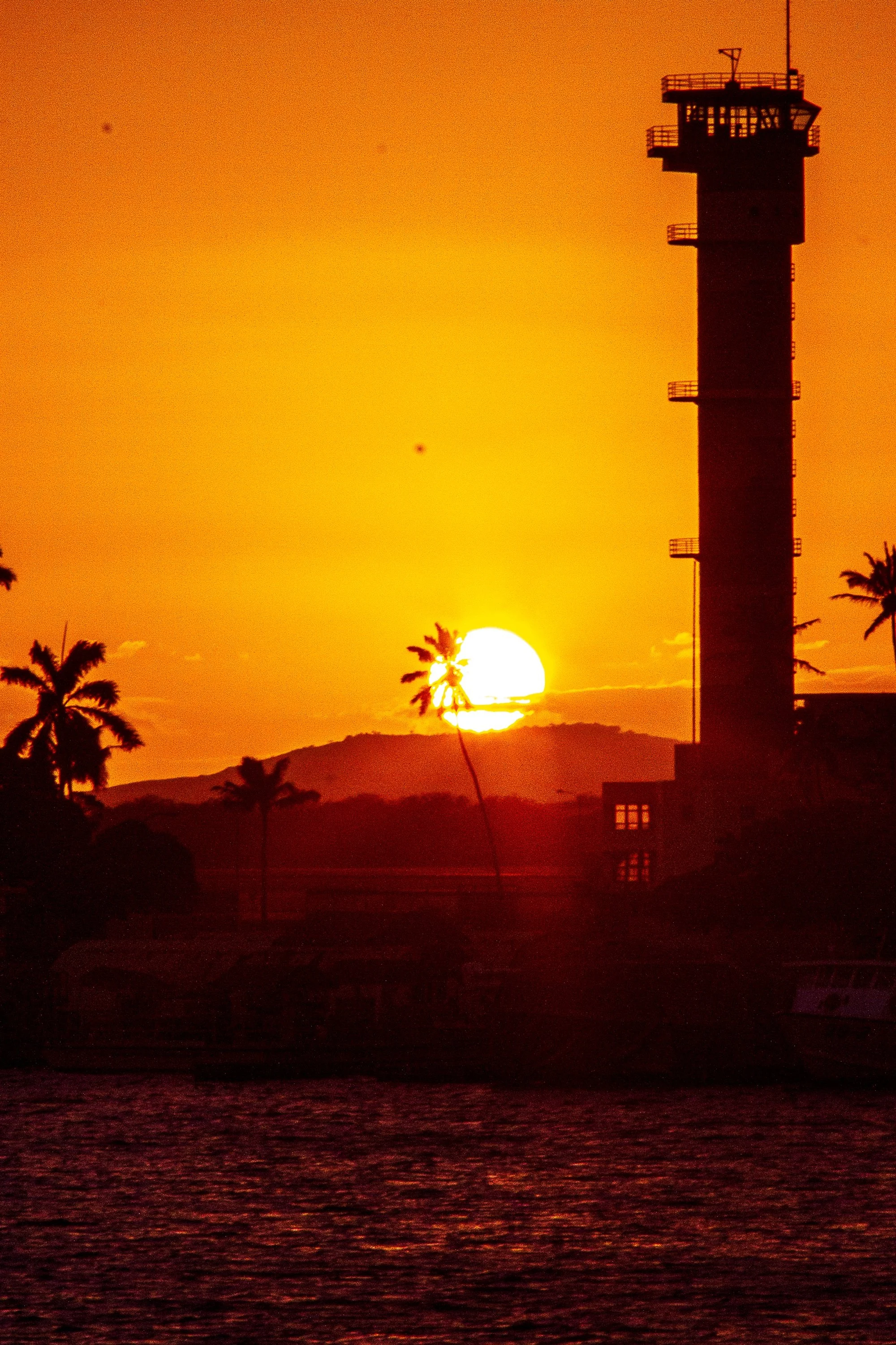 Detail crop from Last Watch, emphasizing small antennas, palms, and water lines hold detail inside the strong orange silhouette