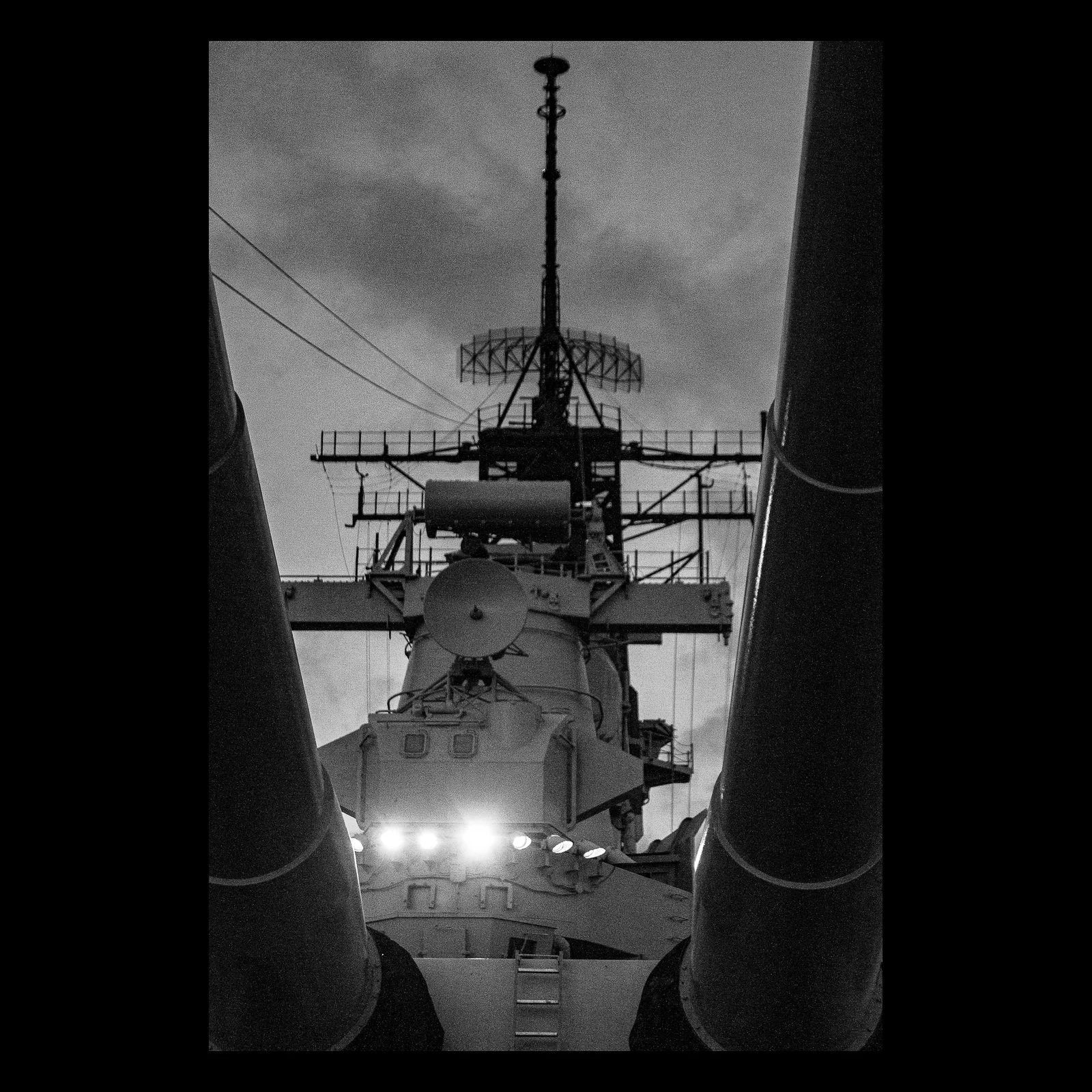 Full-frame black presentation thumbnail of Deck Geometry, showing a ship's superstructure rises in black and white between two dark vertical forms