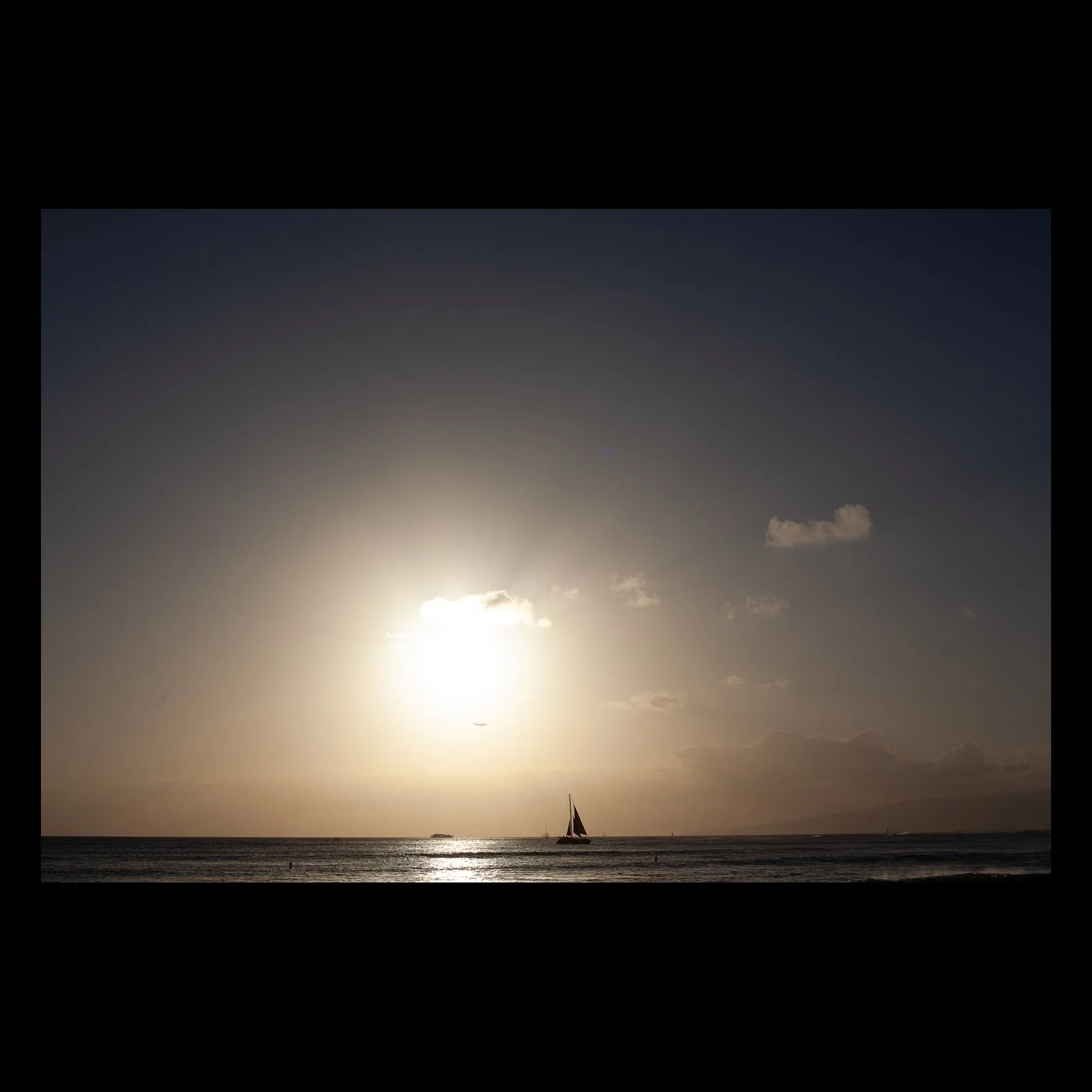 Full-frame black presentation thumbnail of Small Sail, Wide Sun, showing a small sailboat crosses beneath a pale sun and a broad hazy sky