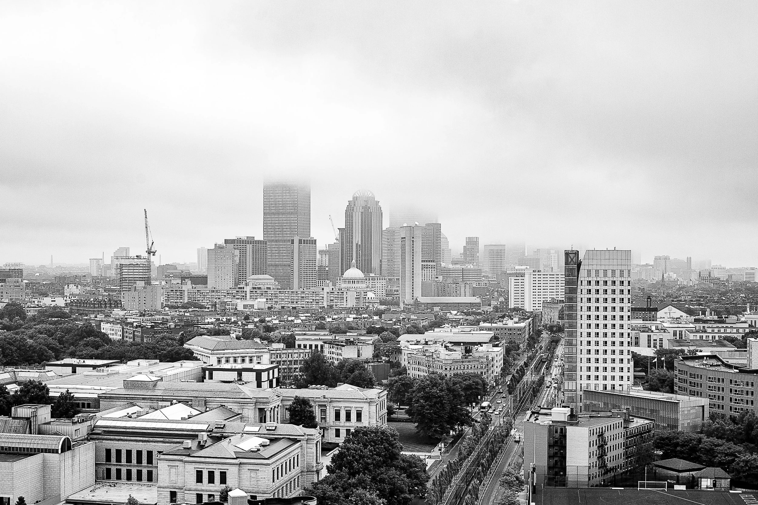 Complete uncropped artwork for City in Gray, showing a city center recedes beneath low fog in a restrained black-and-white view