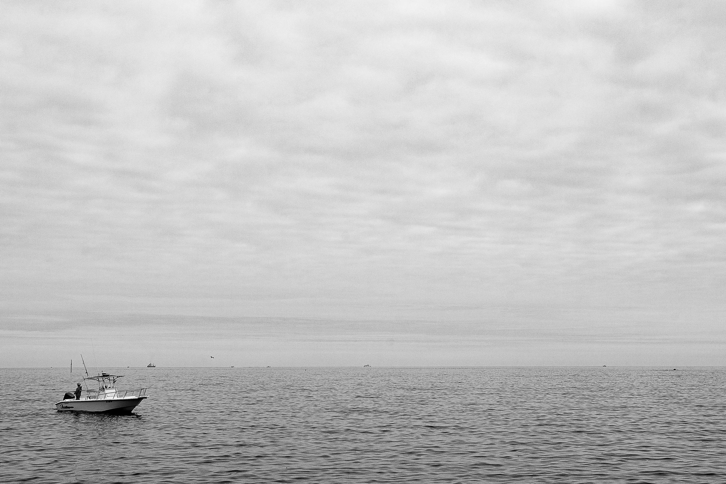 Detail crop from A Boat in the Blank, emphasizing soft cloud bands and nearly empty water become more distinct around the boat