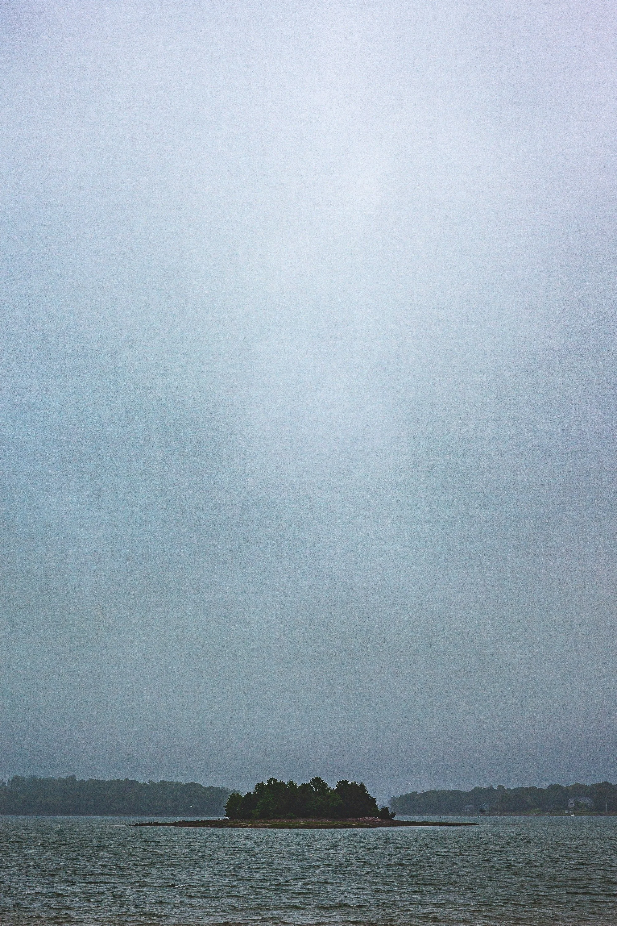 Complete uncropped artwork for Rain Between Shores, showing a distant island appears beneath a vertical veil of rain in a cool-toned seascape