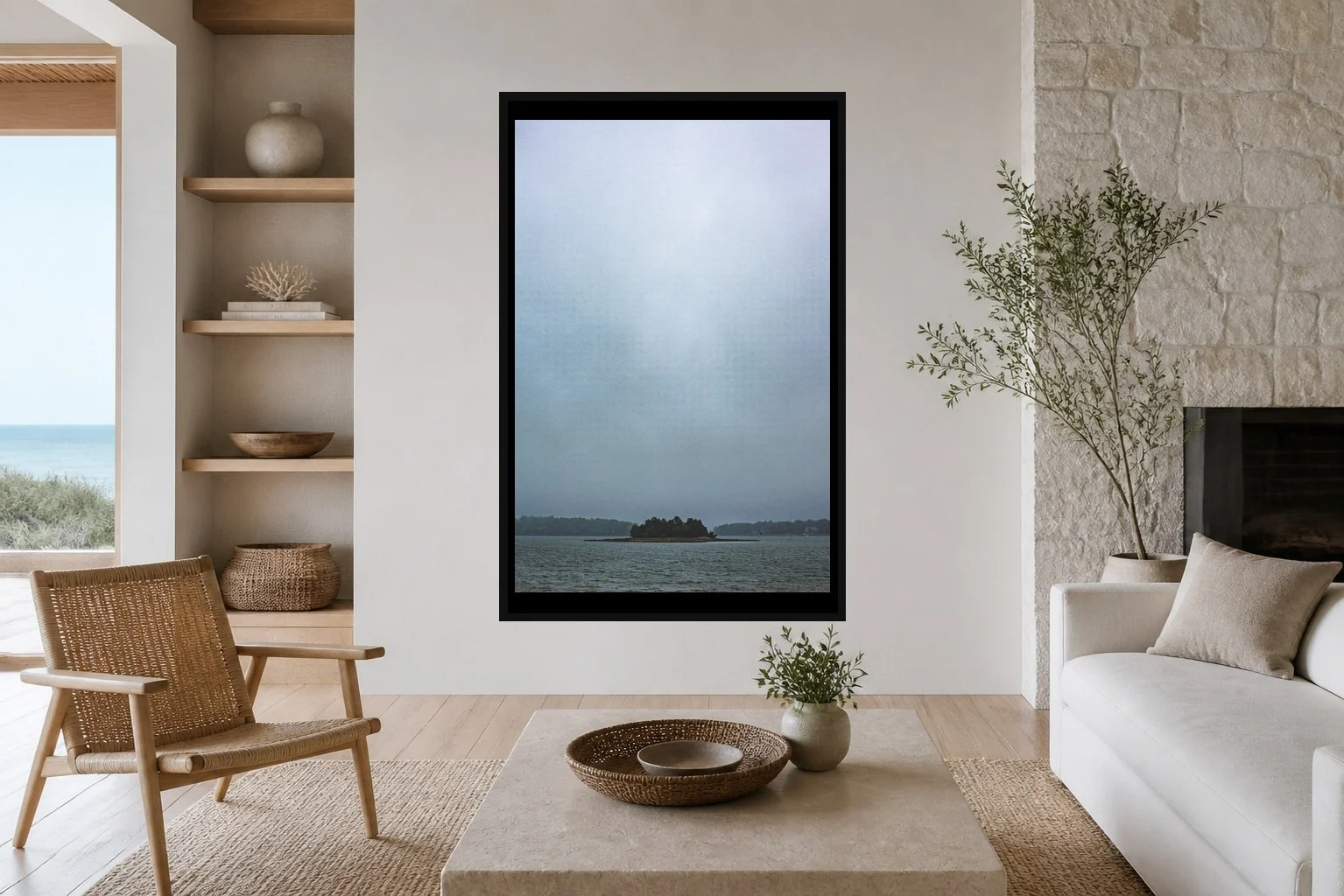 Rain Between Shores displayed in a black frame within a restrained coastal residence with pale stone, white oak, woven seating, and a clear central wall