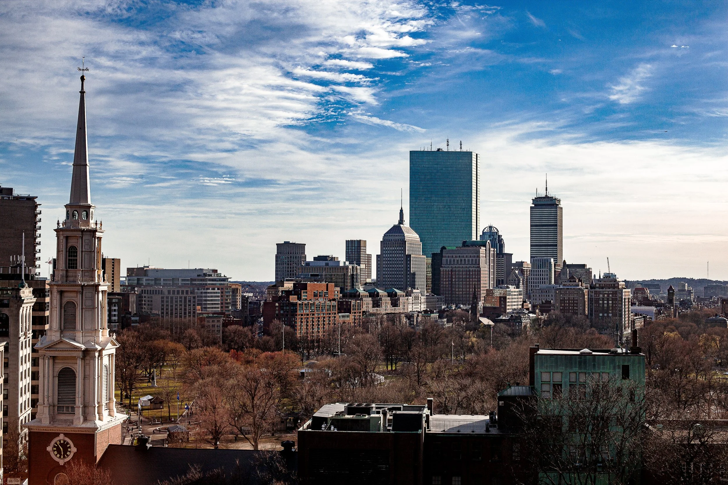 Complete uncropped artwork for Spires and Glass, showing historic church spires and modern glass towers share a layered urban skyline