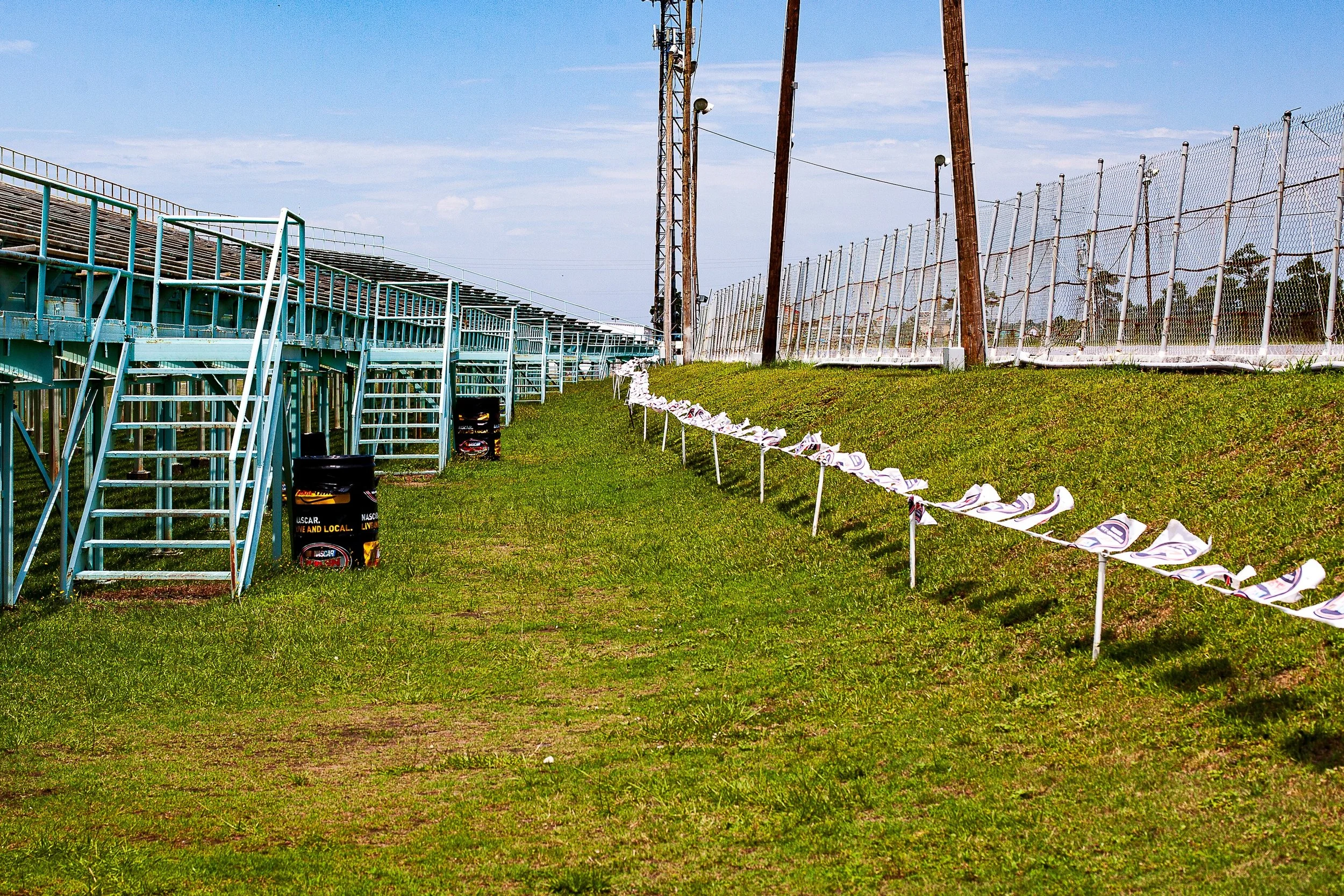 Detail crop from Grandstand After Summer, emphasizing stairs, poles, and weathered rails create a precise visual cadence