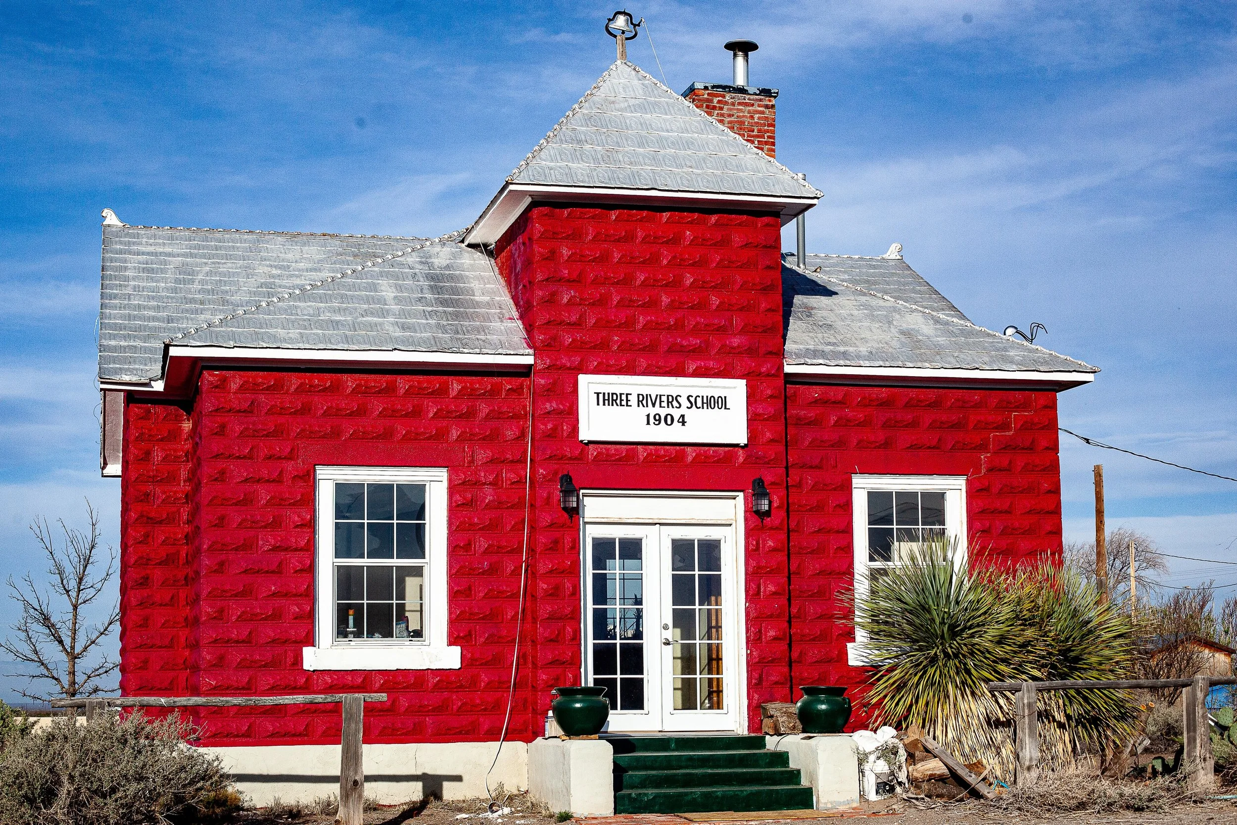 Complete uncropped artwork for The Red Schoolhouse, showing a bright red historic schoolhouse stands alone beneath a blue sky
