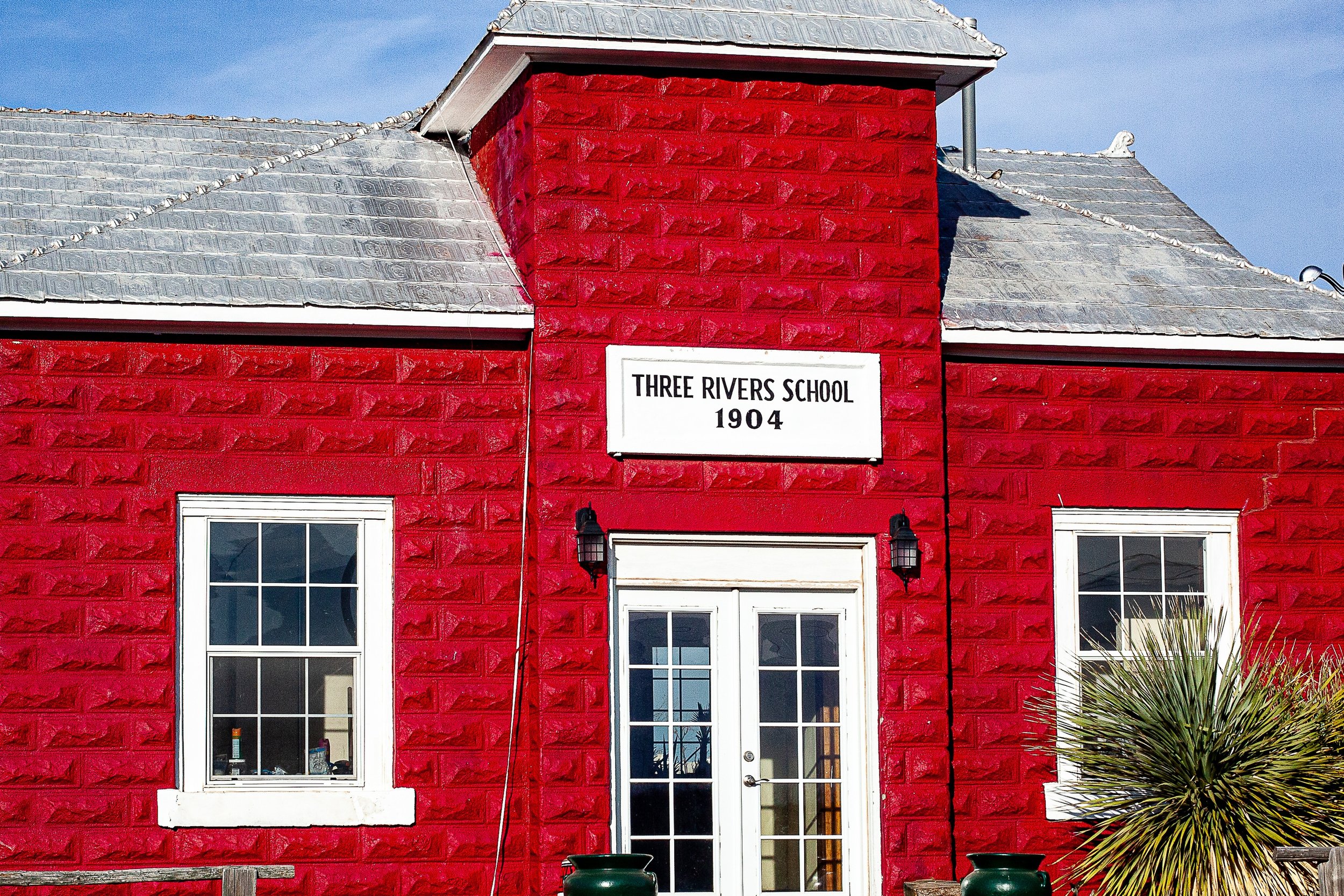 Detail crop from The Red Schoolhouse, emphasizing white trim, roof angles, and the centered doorway sharpen its compact character