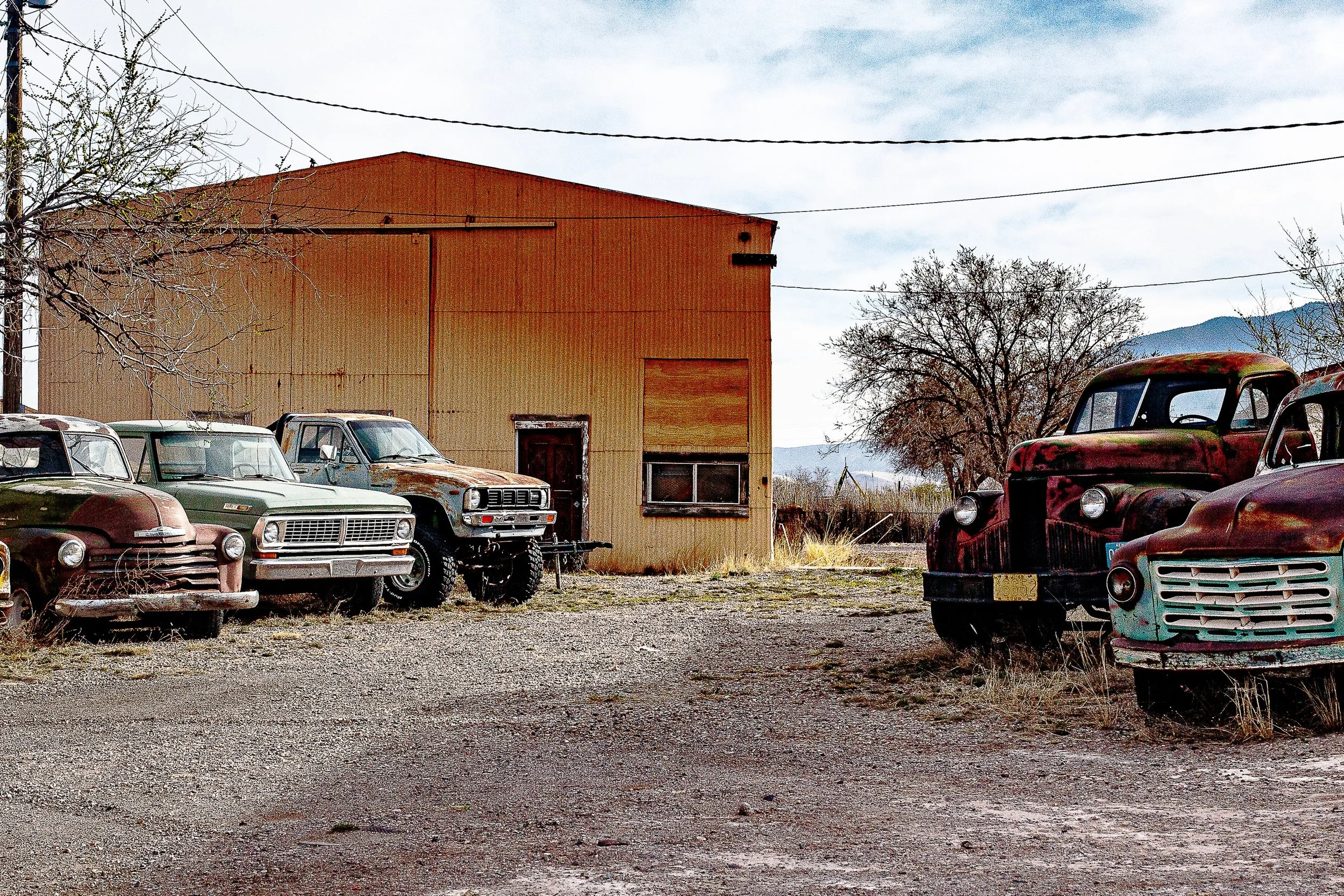 Detail crop from Working Relics, emphasizing rust, flat tires, and patched bodywork reveal years of practical use