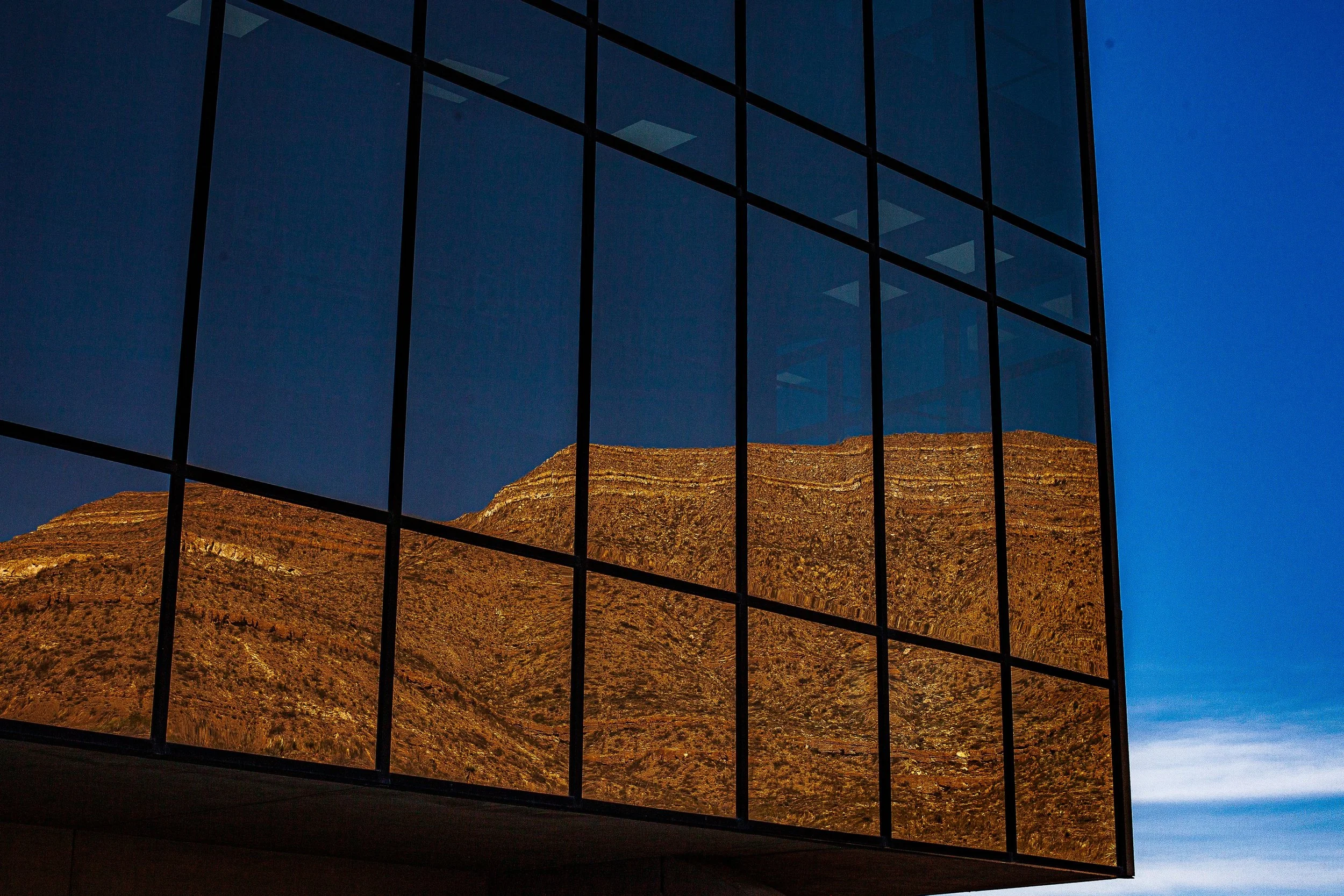 Complete uncropped artwork for Borrowed Mountain, showing a golden mountain appears as a reflection across a grid of dark glass