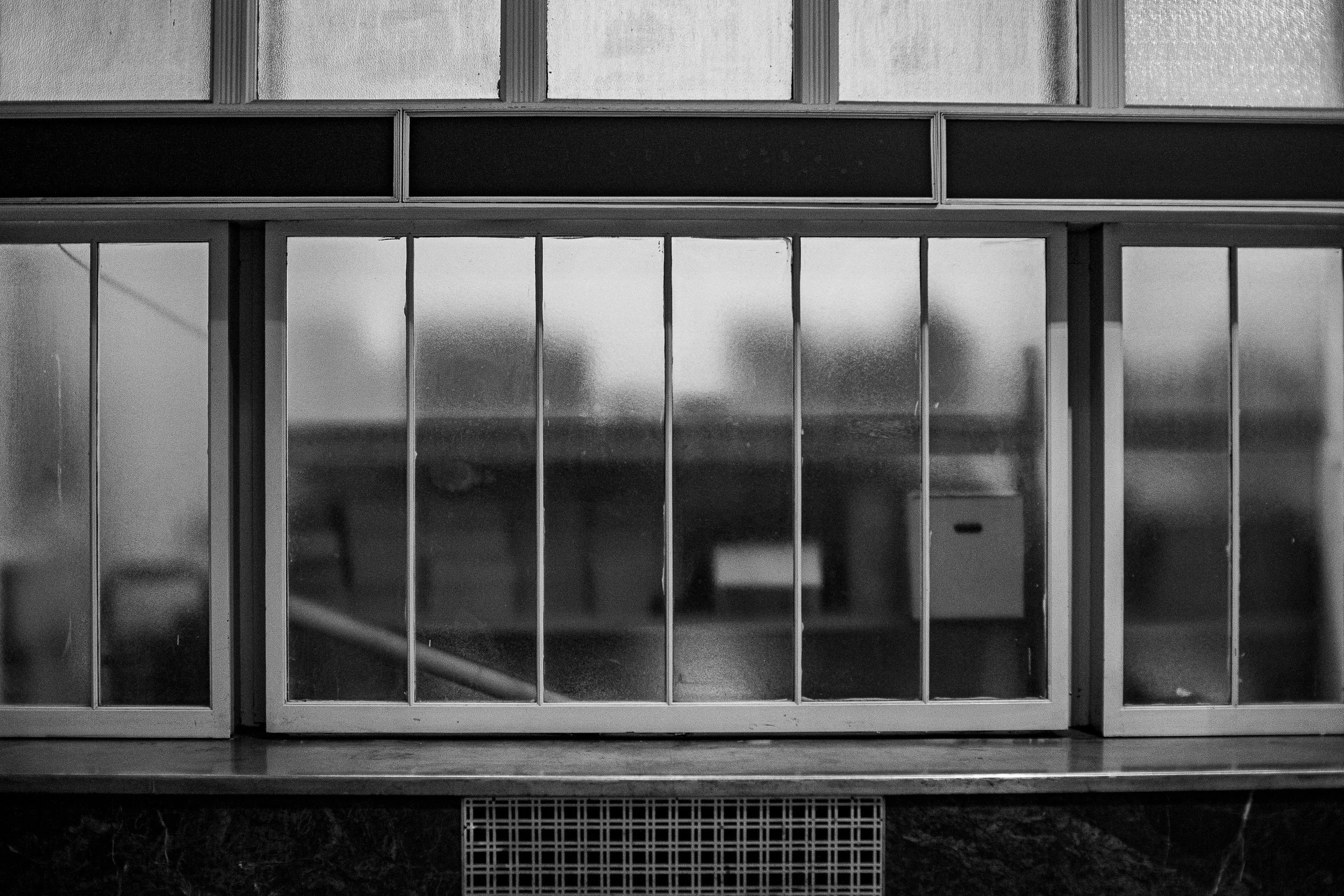 Complete uncropped artwork for Frosted Interior, showing industrial windows form a black-and-white grid of translucent panes and blurred shapes