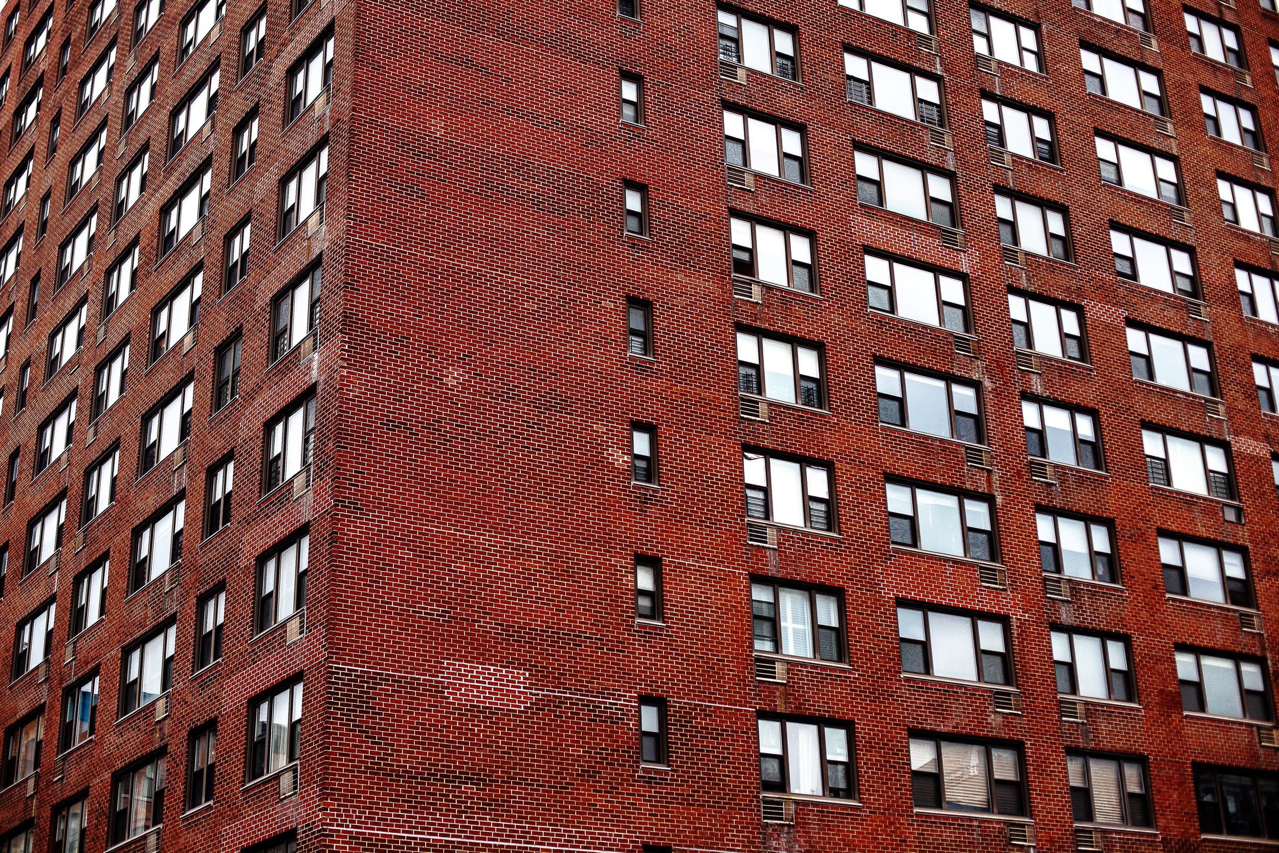 Complete uncropped artwork for Brick Repetition, showing rows of windows repeat across a tall red-brick residential facade