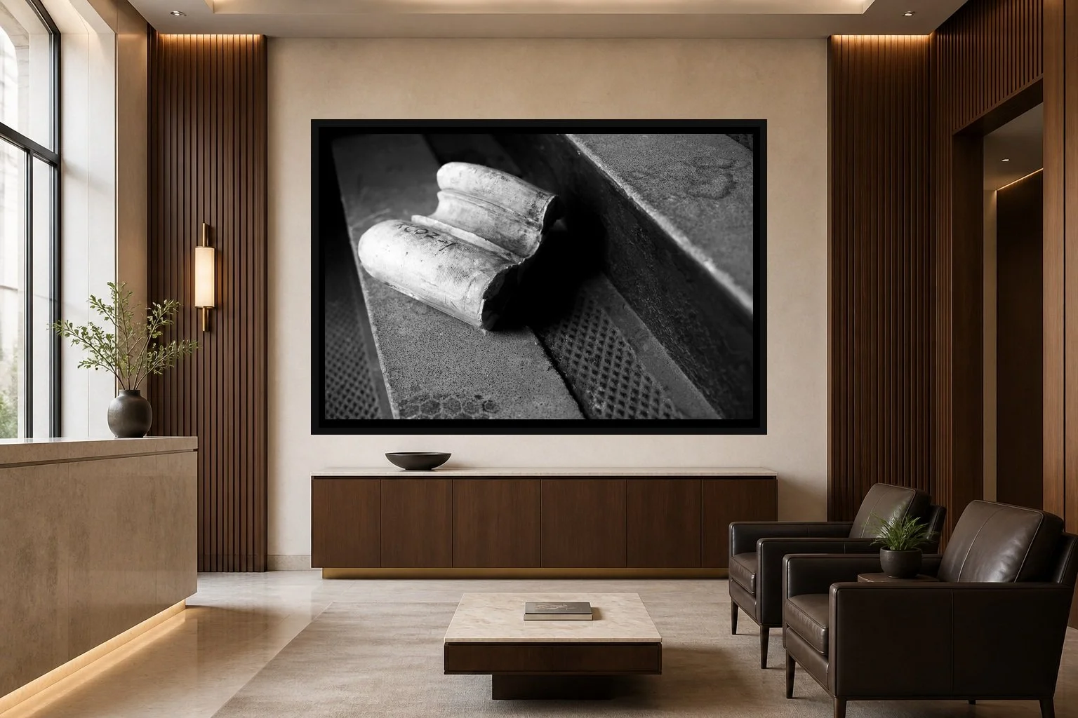 Fallen Fragment displayed in a black frame within an upscale law-office reception area with honed stone, walnut paneling, quiet seating, and a clear central wall