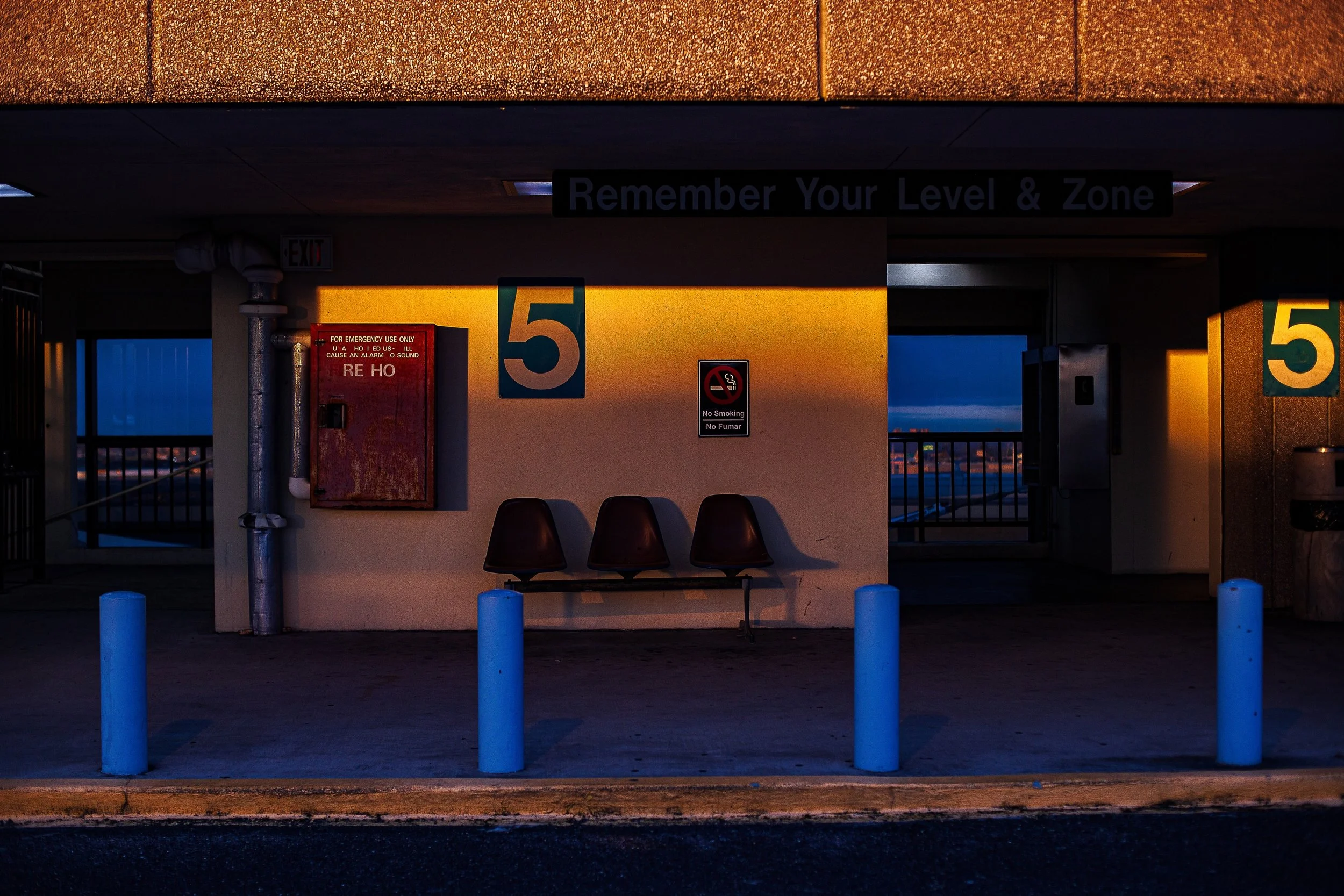 Complete uncropped artwork for Remember Level Five, showing an empty parking level glows blue and amber around a large numeral five