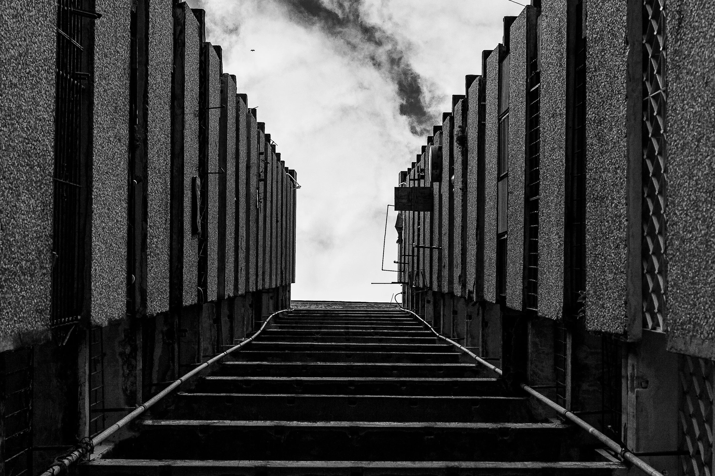 Detail crop from Industrial Ascent, emphasizing fences, shadows, and rooftop equipment deepen the severe geometry