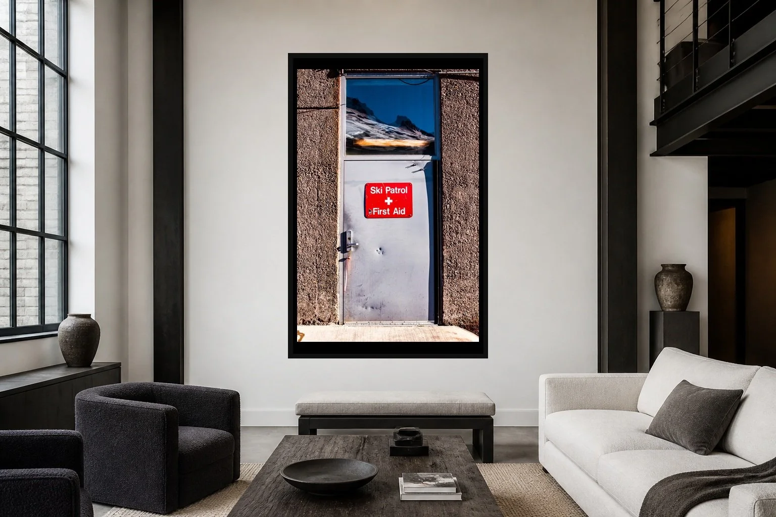 First Aid displayed in a black frame within a modern collector's loft with white plaster, blackened steel, textured fabrics, and a clear central wall