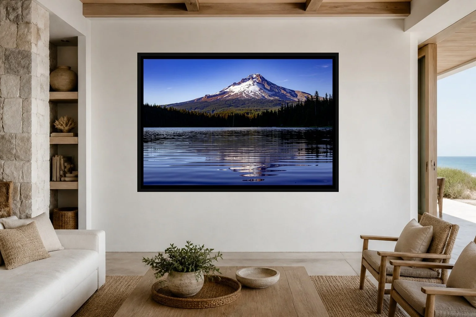 Mountain in Reflection displayed in a black frame within a restrained coastal residence with pale stone, white oak, woven seating, and a clear central wall