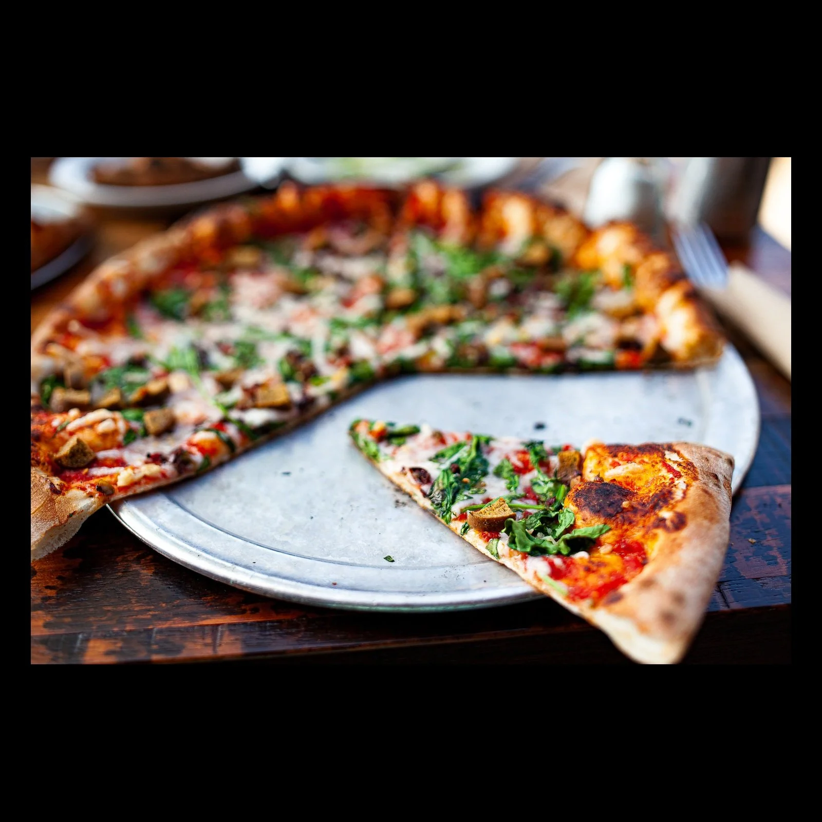 Full-frame black presentation thumbnail of Last Slice, showing a single slice has been pulled from a pizza, leaving a bright wedge of empty metal tray