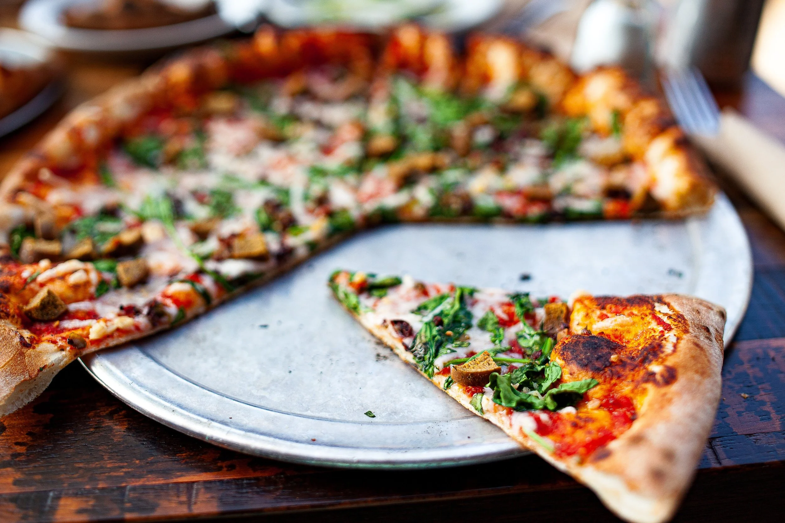 Complete uncropped artwork for Last Slice, showing a single slice has been pulled from a pizza, leaving a bright wedge of empty metal tray