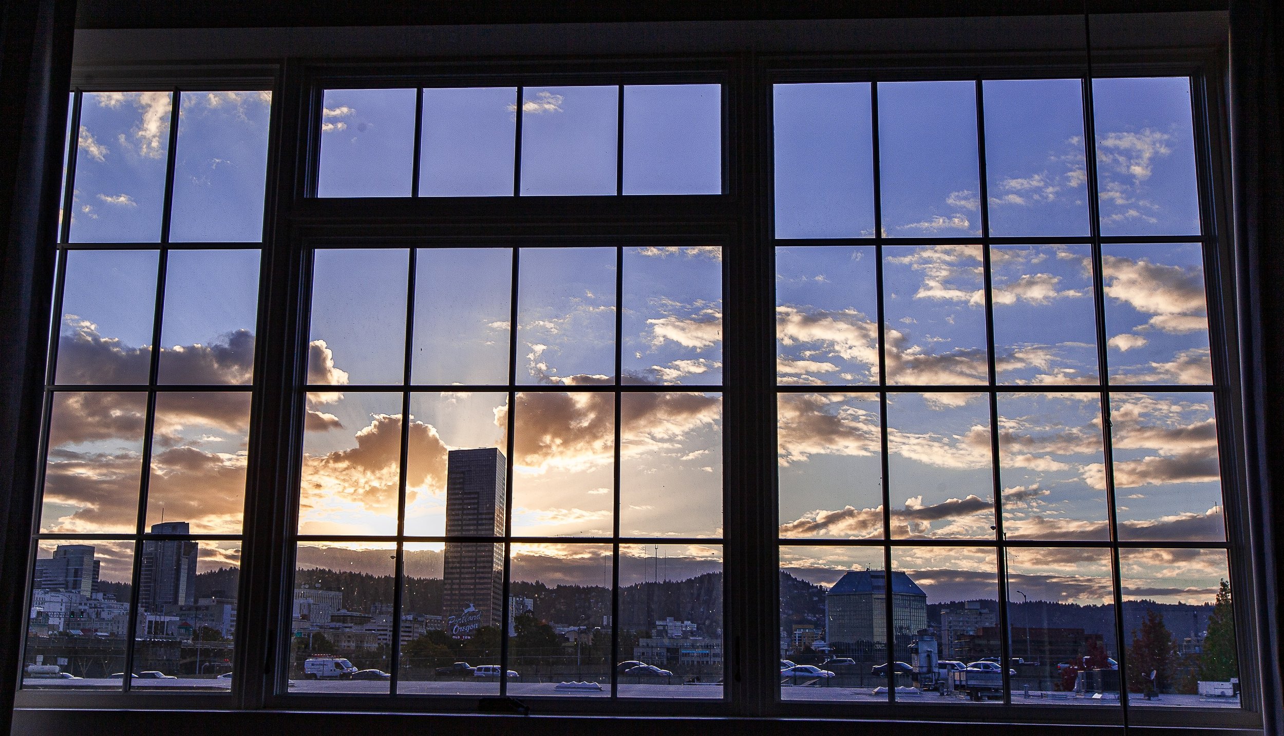 Complete uncropped artwork for Window Weather, showing a sunset and scattered clouds are divided by the dark grid of a large industrial window
