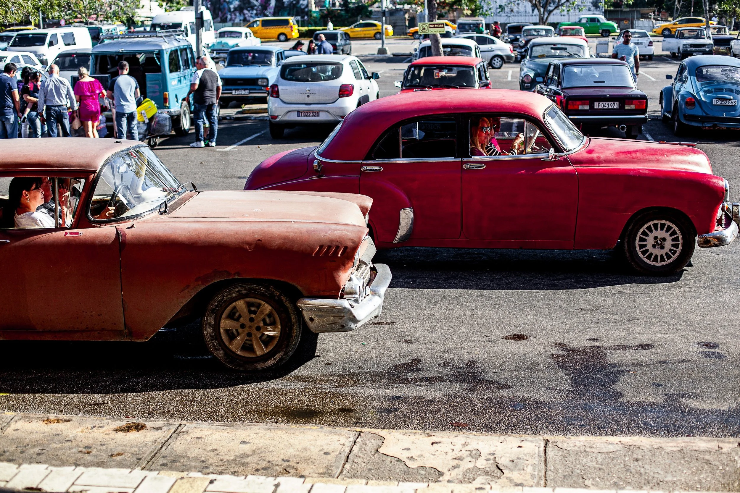 Complete uncropped artwork for A Step Back in Time, showing two vintage cars cross a busy street in opposing directions amid dense traffic