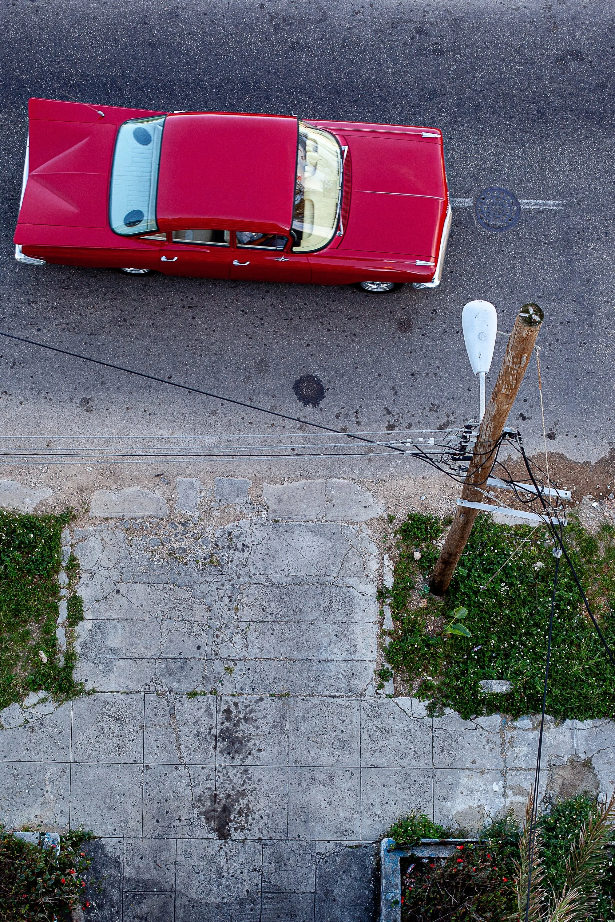 Detail crop from 59 Impala, emphasizing curbs, cracks, and vegetation reveal the uneven geometry around it