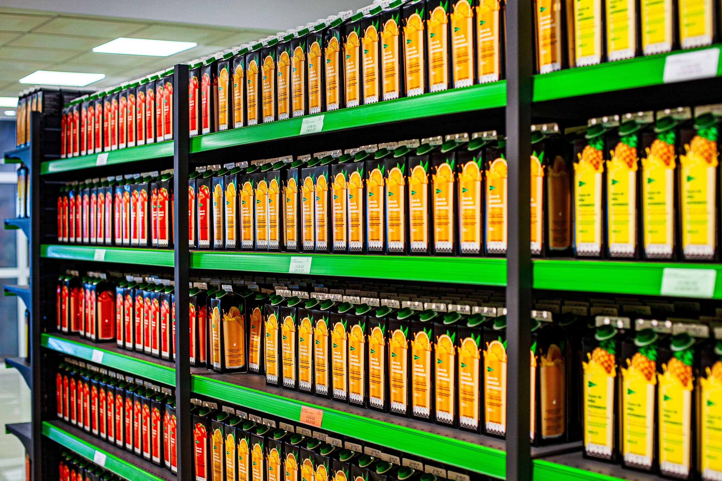 Complete uncropped artwork for Repetition in Orange, showing long shelves of orange and yellow bottles recede through a brightly lit store